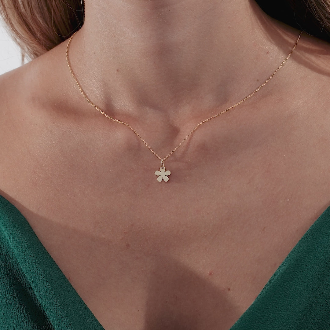 Model wearing a 14K solid yellow gold daisy flower necklace, showcasing its elegant design and minimalist style.