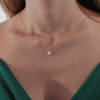 Model wearing a 14K solid yellow gold daisy flower necklace, showcasing its elegant design and minimalist style.
