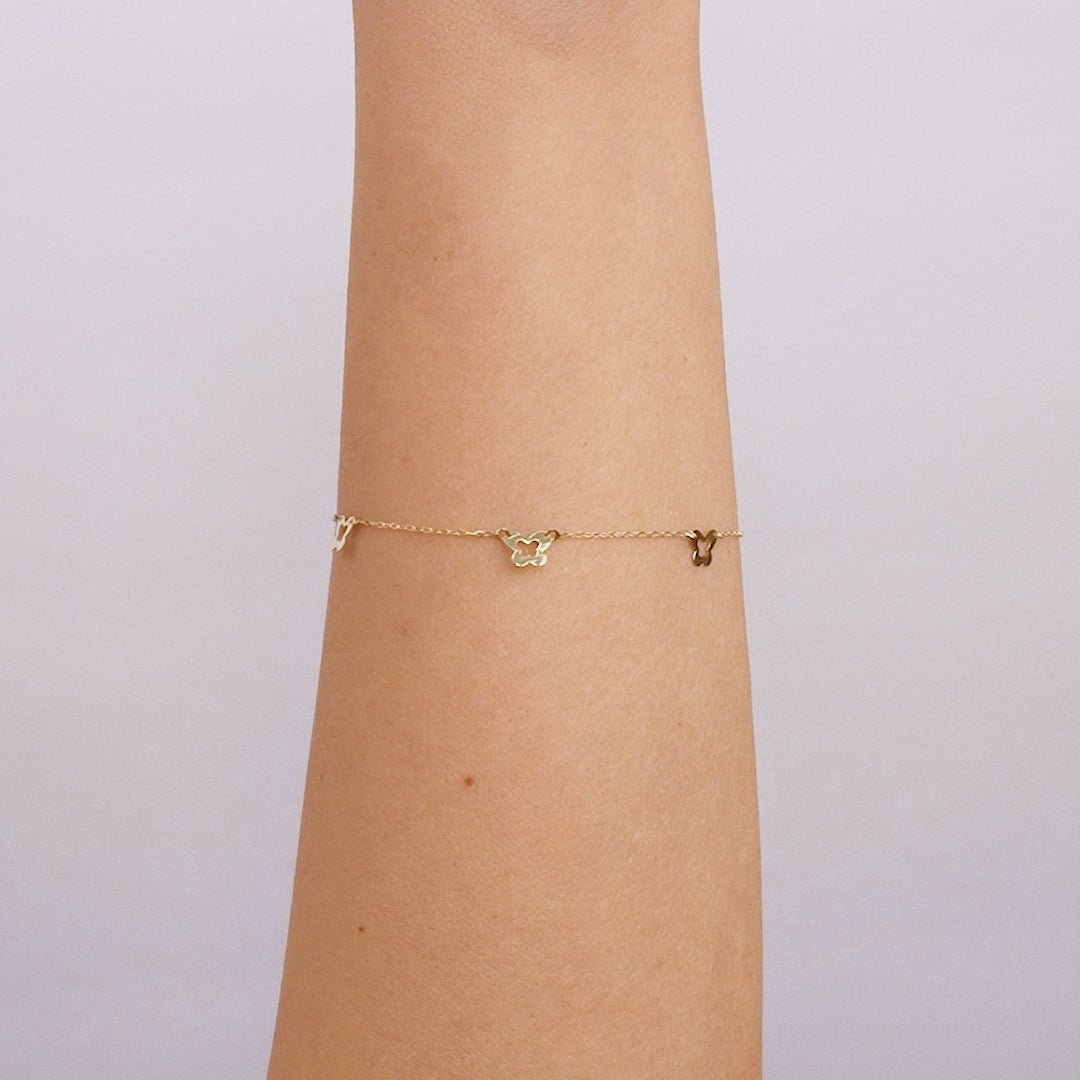 14K solid yellow gold small butterfly station bracelet worn on wrist, showcasing delicate design and dainty butterflies.
