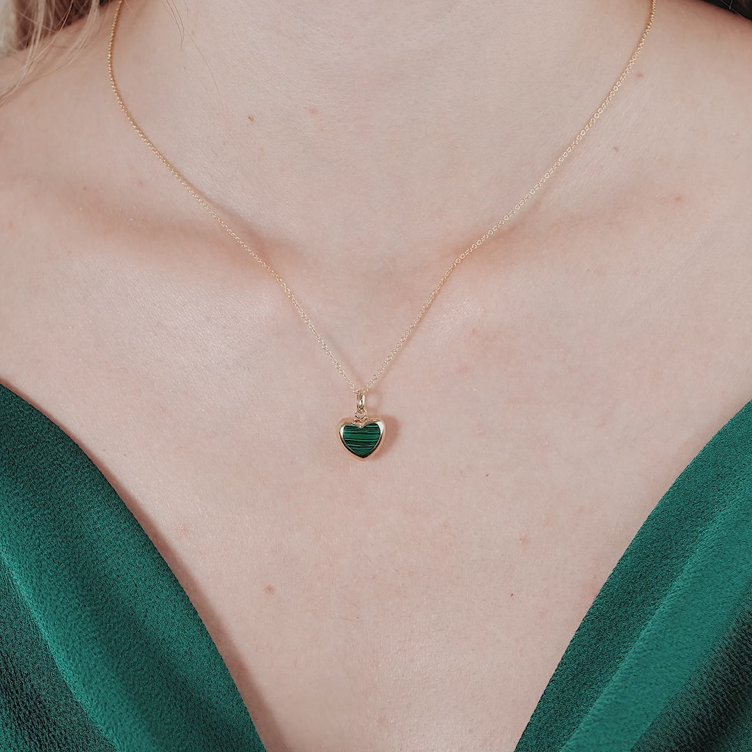 Model wearing a 14K yellow gold malachite puffed heart necklace, showcasing its unique charm and elegance.