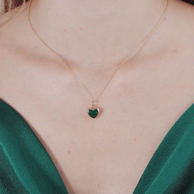 Model wearing a 14K yellow gold malachite puffed heart necklace, showcasing its unique charm and elegance.