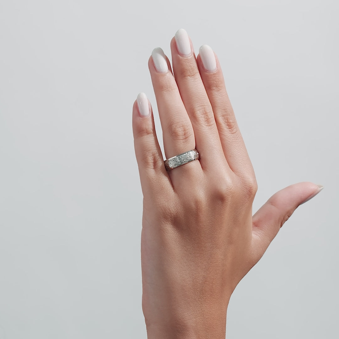 14K white gold hand engraved wedding band on woman’s hand with manicured nails, showcasing leaf motifs and shiny finish.