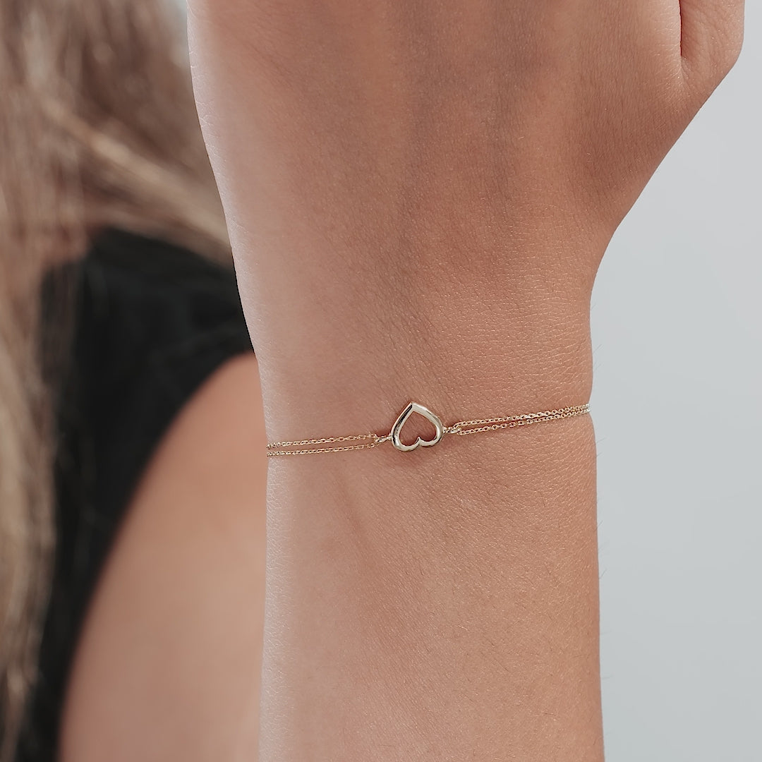 14K yellow gold open heart bracelet worn on a wrist, showcasing its delicate and classy design, perfect for everyday use.