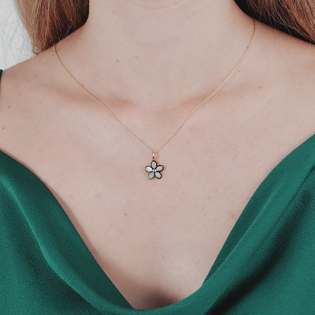 Model wearing a 14K yellow gold daisy flower necklace with mother of pearl detail, perfect for everyday elegance.