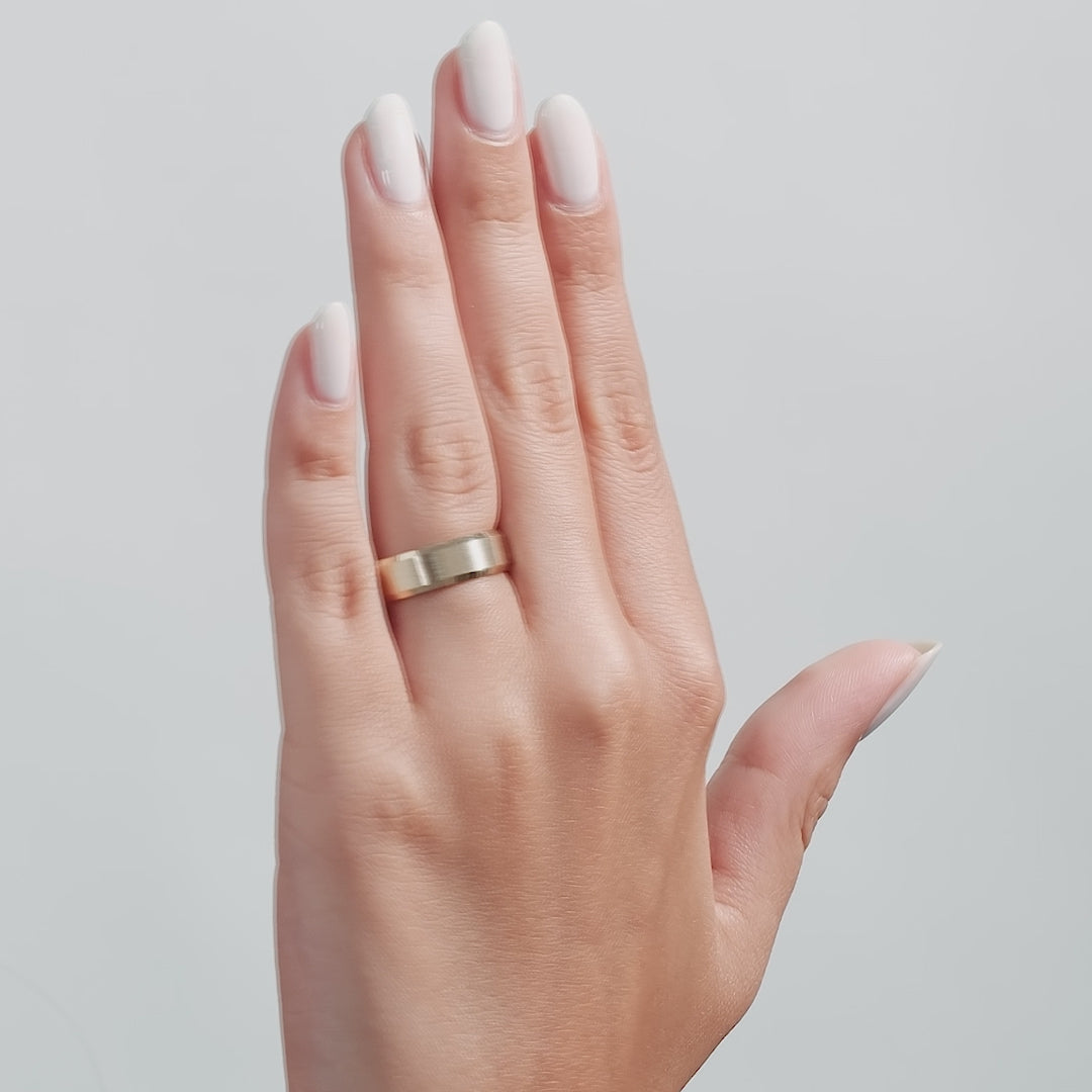 Elegant 6mm solid white gold men's wedding band with a satin finish and shiny edges, worn on a hand with manicured nails.