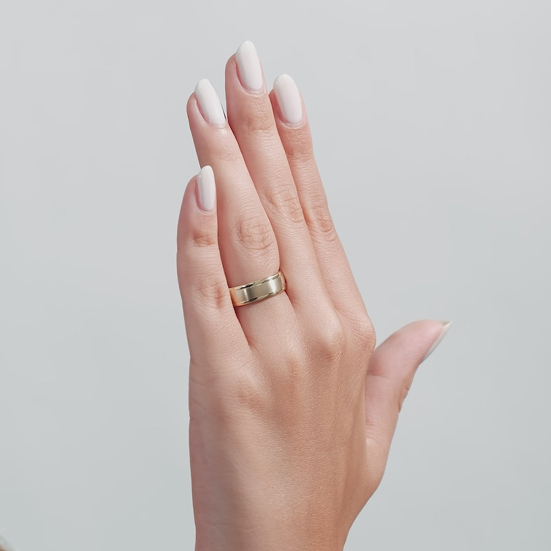 Hand displaying a 6mm 10K 14K 18K yellow gold men's wedding band with a satin finish.