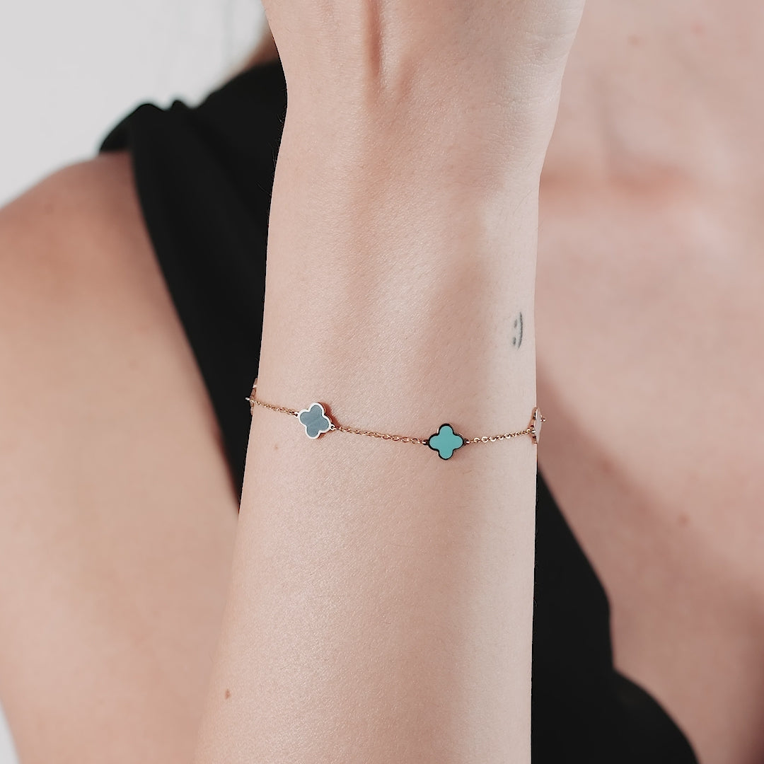 14K solid yellow gold four leaf clover bracelet with turquoise and mother of pearl, worn on wrist.