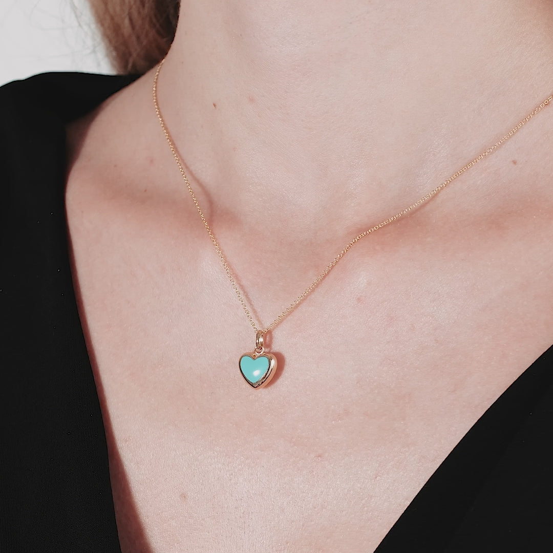 14K yellow gold turquoise puffed heart necklace worn on a woman's neck, showcasing elegance and charm.