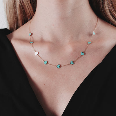 14K solid yellow gold turquoise heart necklace worn by a model, featuring a delicate design with lobster clasp.