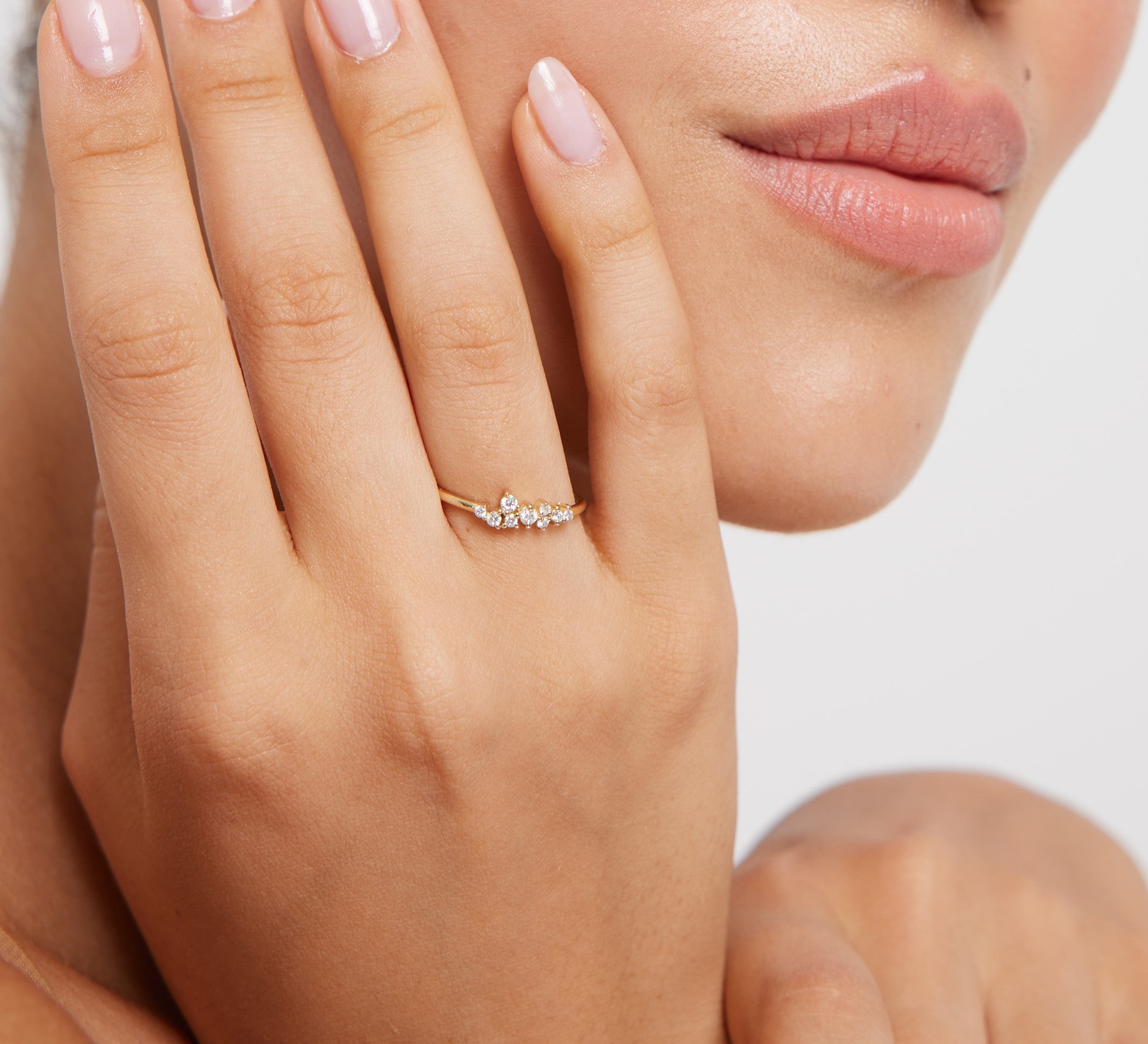 Wearing a 14K yellow gold minimalist diamond cluster ring on a hand.