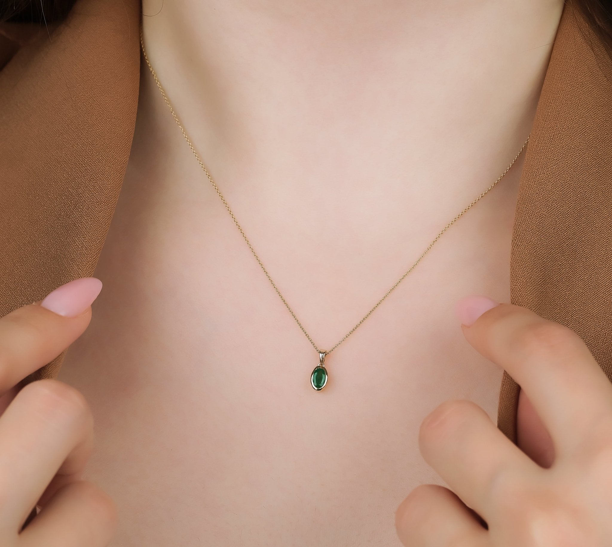 14K gold natural emerald solitaire necklace displayed on a model, featuring a delicate design with a 0.25ct emerald pendant.