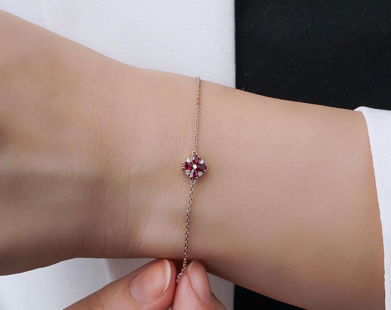 14K gold bracelet with lab-created rubies and diamonds, showcasing a detailed design on a wrist.