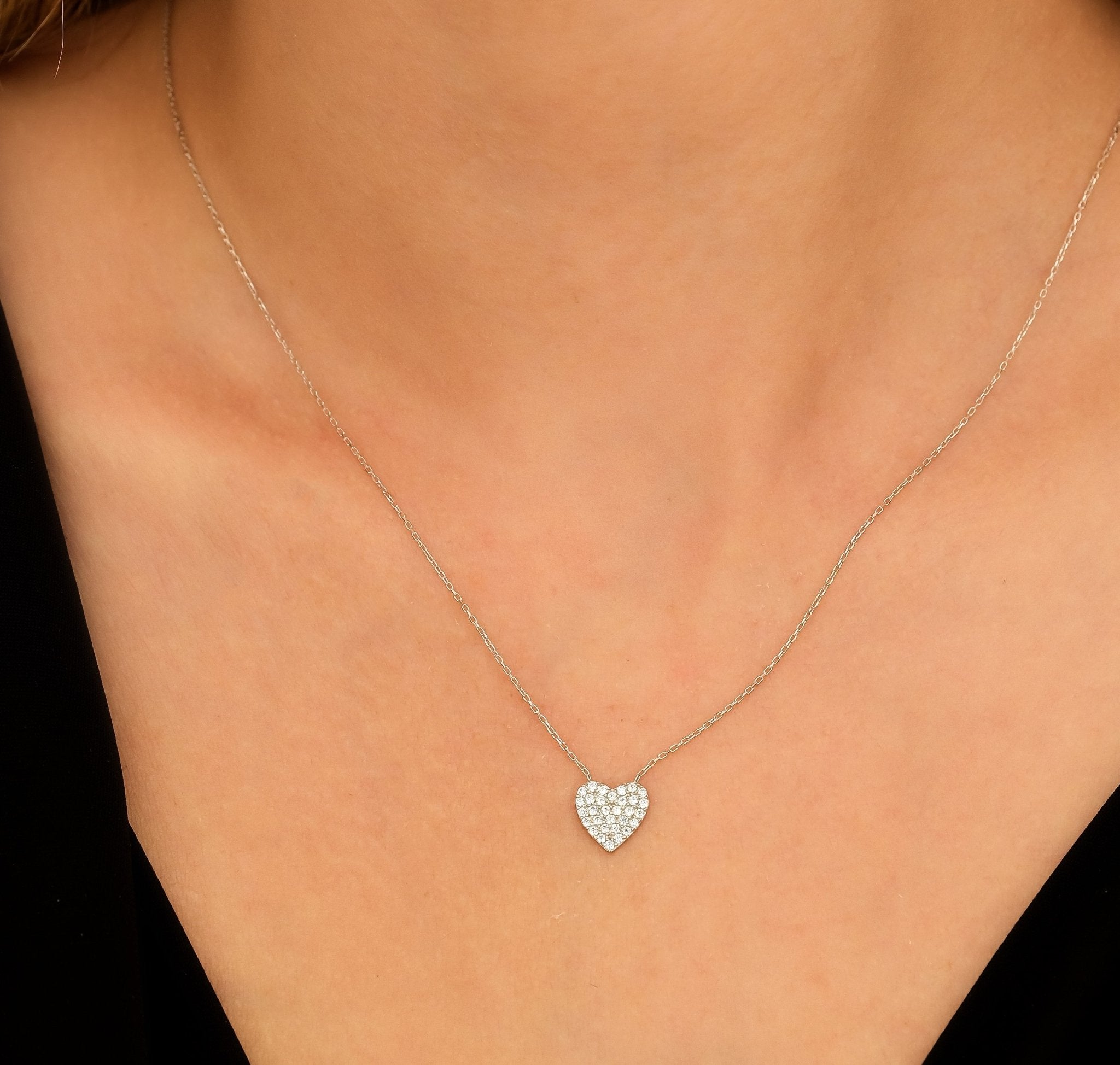14K solid white gold dainty heart necklace with CZ, elegantly worn, showcasing its delicate design and shine.