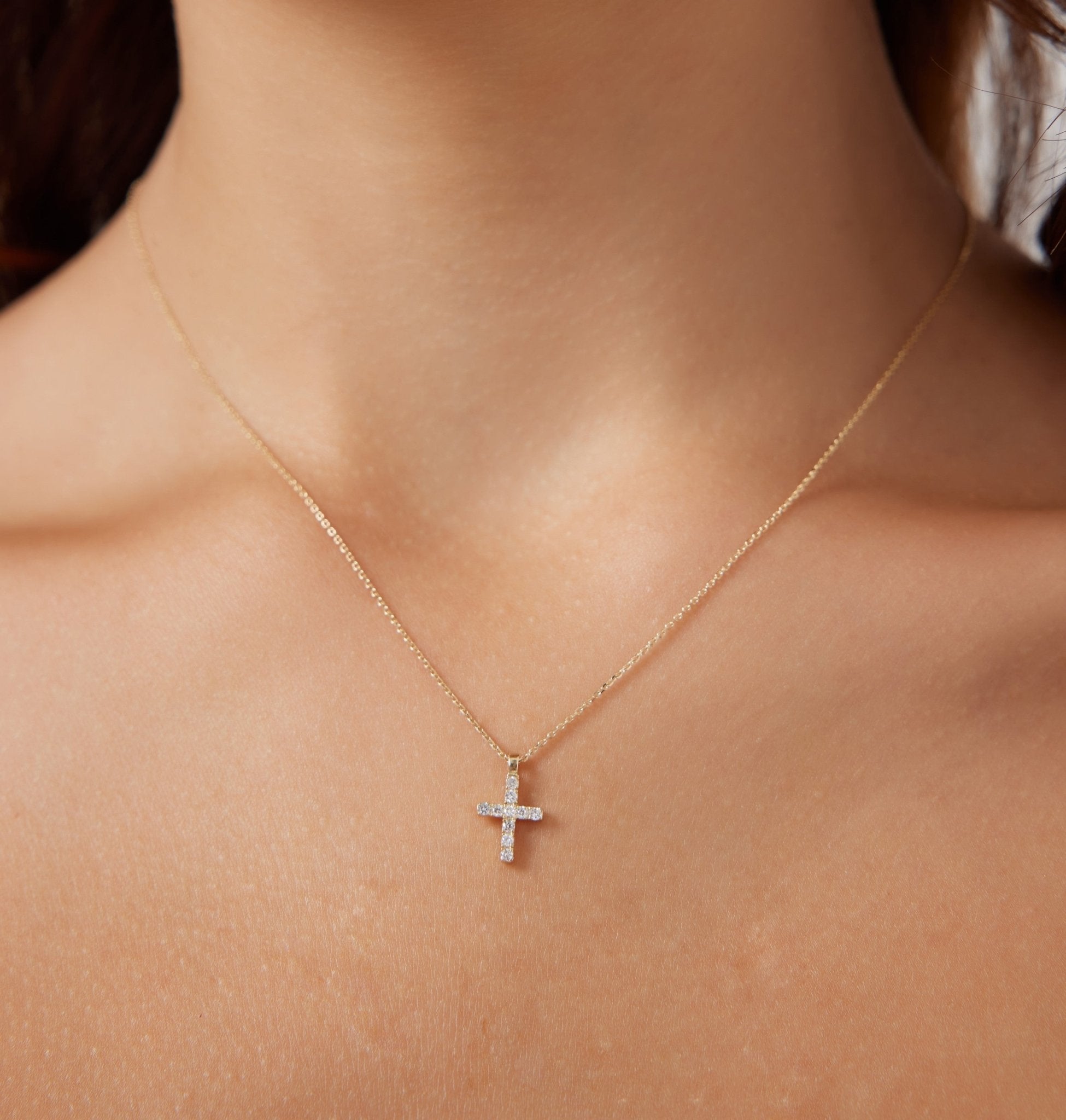 14K solid white gold minimalist diamond cross necklace worn on a woman's neck, showcasing dainty design and sparkle.