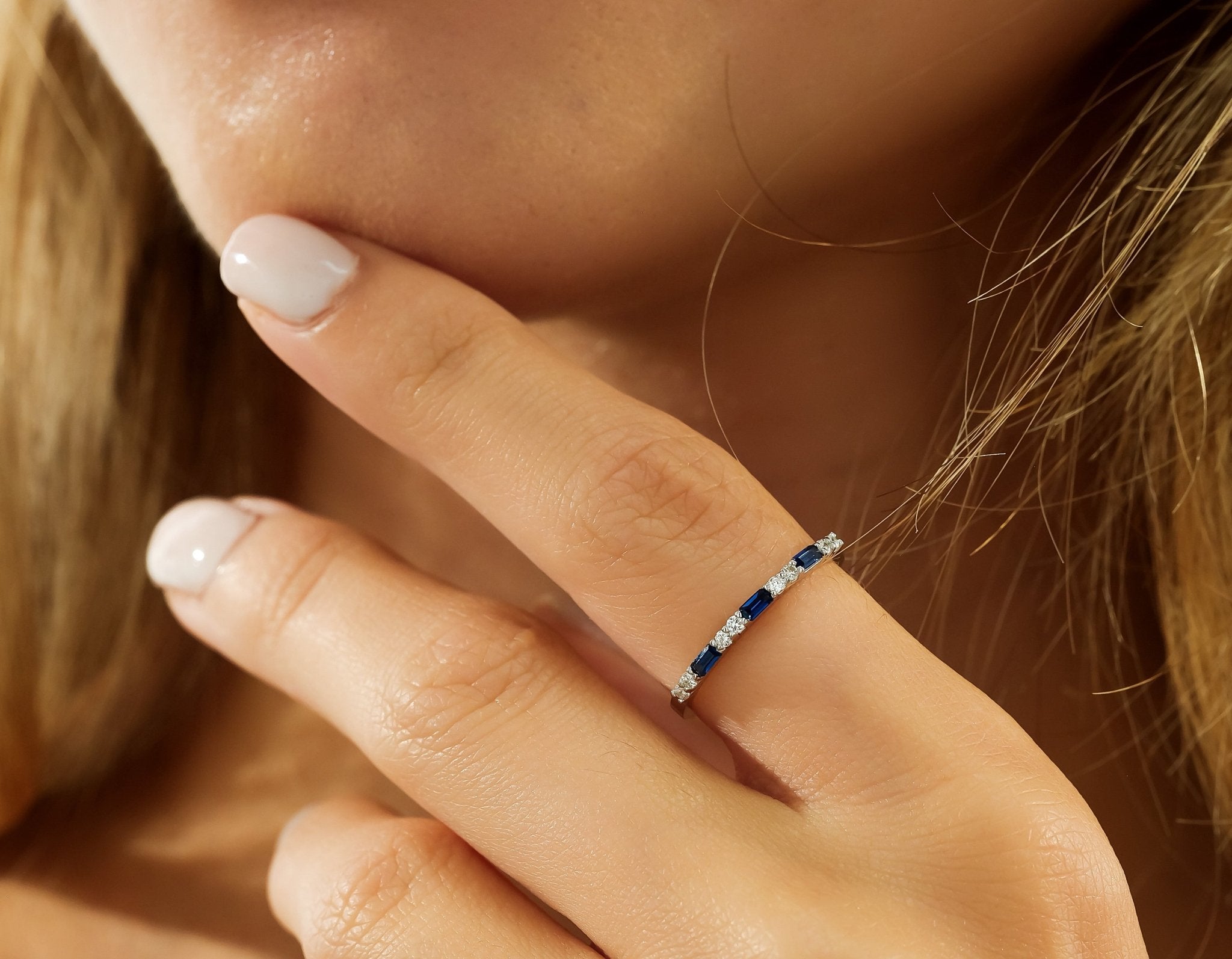 14K solid white gold sapphire and diamond wedding ring displayed on a woman's finger, highlighting its elegant design.
