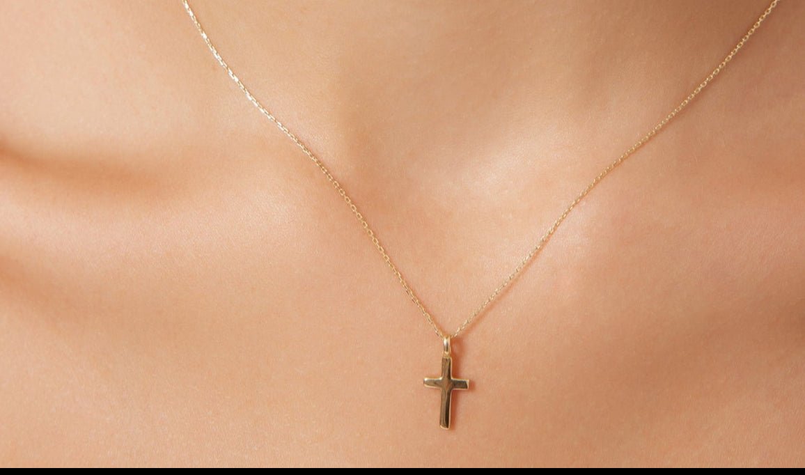 14K solid yellow gold cross necklace worn on a delicate chain, perfect for everyday minimalist style.