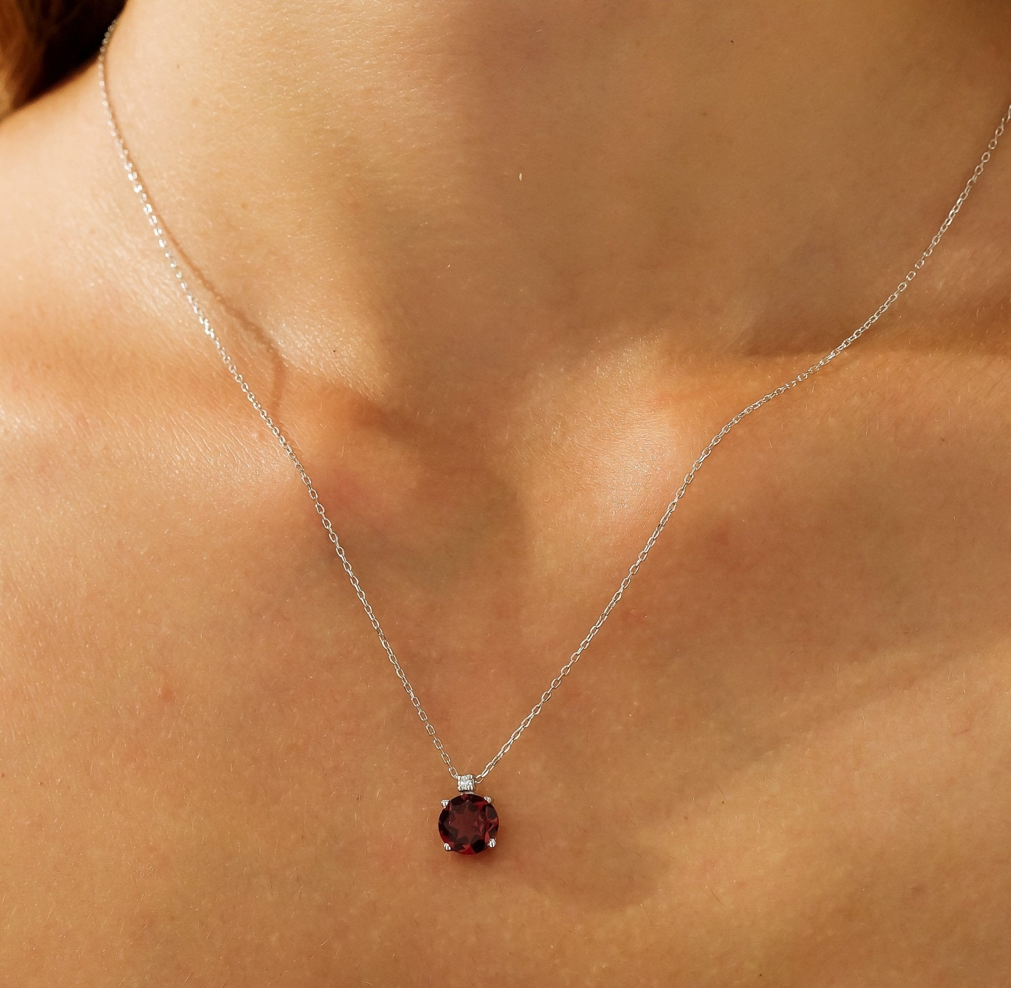 14K solid yellow gold ruby solitaire necklace featuring natural diamond, worn elegantly on a model's neck.