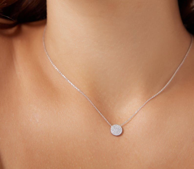 14K yellow gold diamond circle necklace, featuring sparkling white diamonds, worn elegantly on a model's neck.