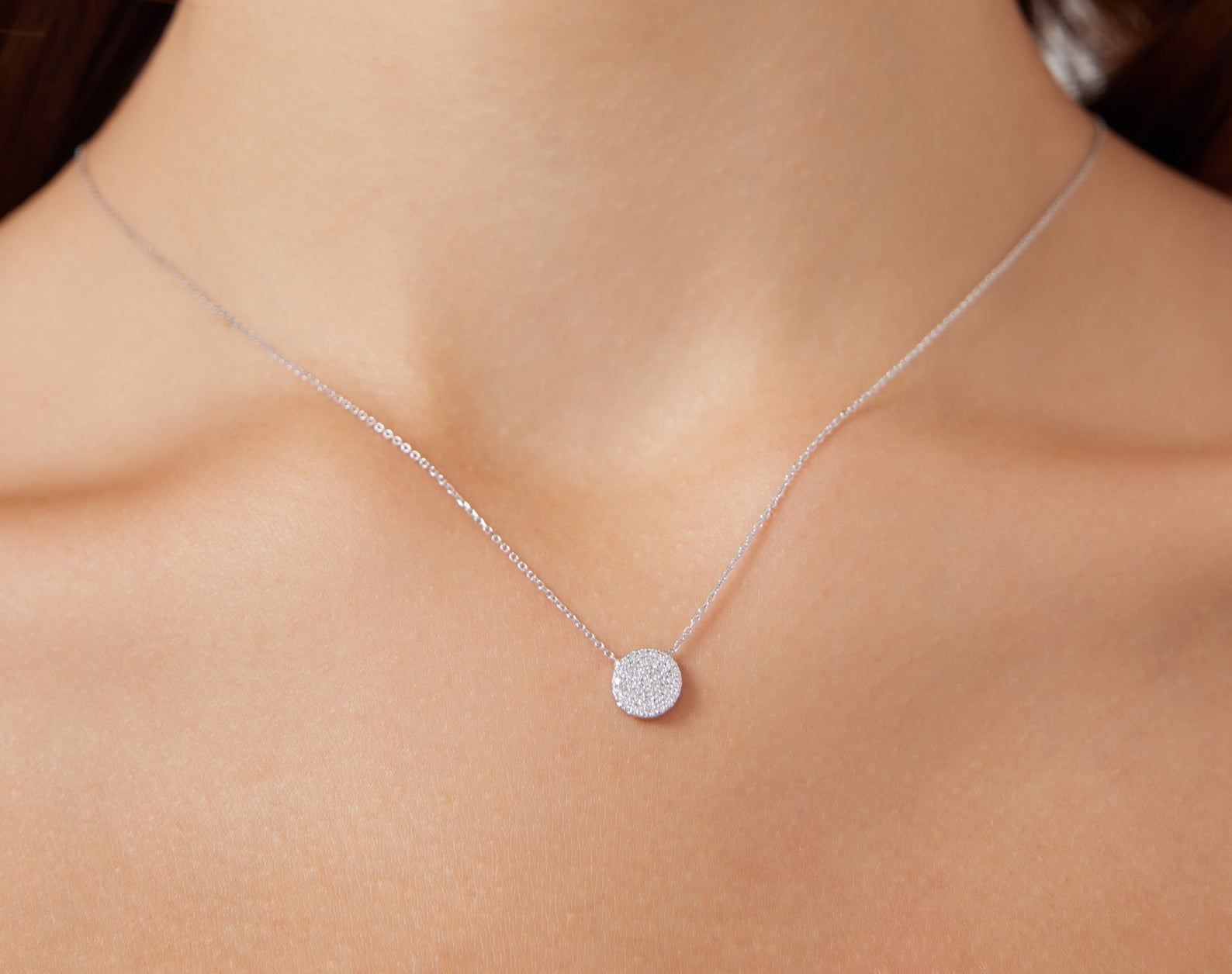 14K yellow gold diamond circle necklace worn on a delicate chain, featuring a shimmering disk pendant.