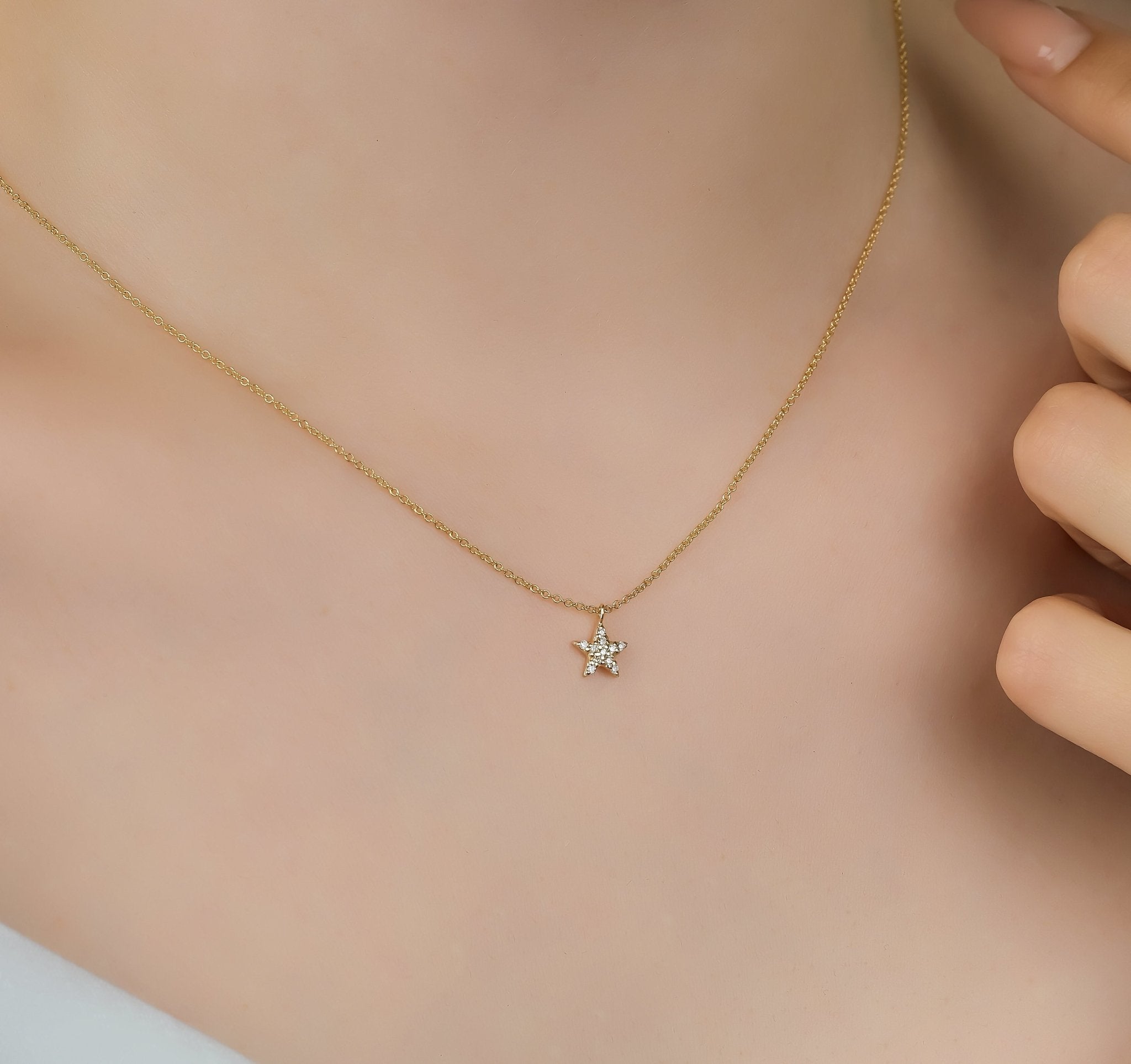 14K solid yellow gold minimalist star necklace with diamonds worn on neck, showcasing its delicate design and sparkle.