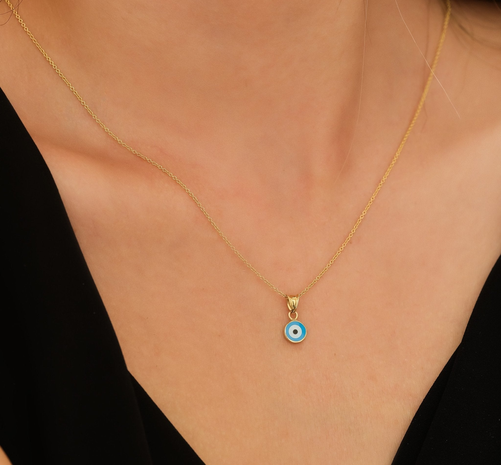 14K solid yellow gold evil eye pendant necklace, featuring a delicate blue eye charm on a gold chain.