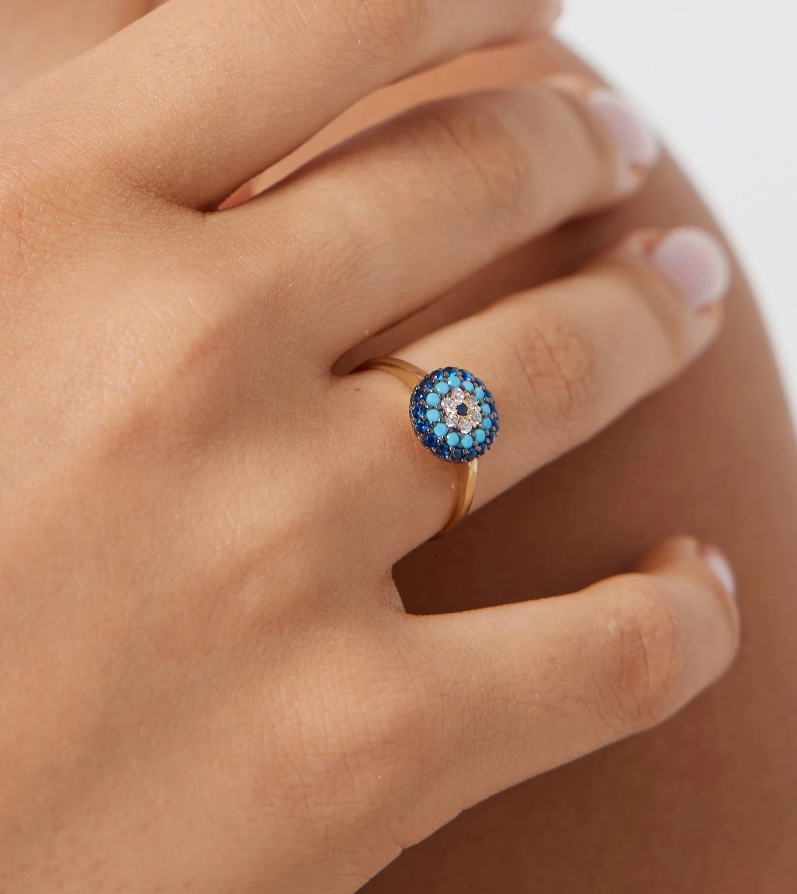 14K solid yellow gold turquoise evil eye ring worn on a hand, featuring intricate blue and white CZ detailing.