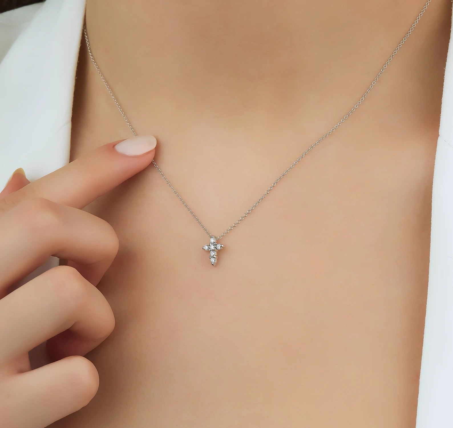 Dainty 14K solid yellow gold minimalist diamond cross necklace on model's neck, showcasing sparkling white diamonds.