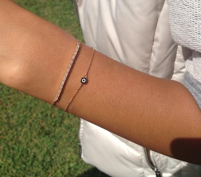 14K solid yellow gold minimalist evil eye bracelet worn on wrist, showcasing a delicate design and everyday elegance.
