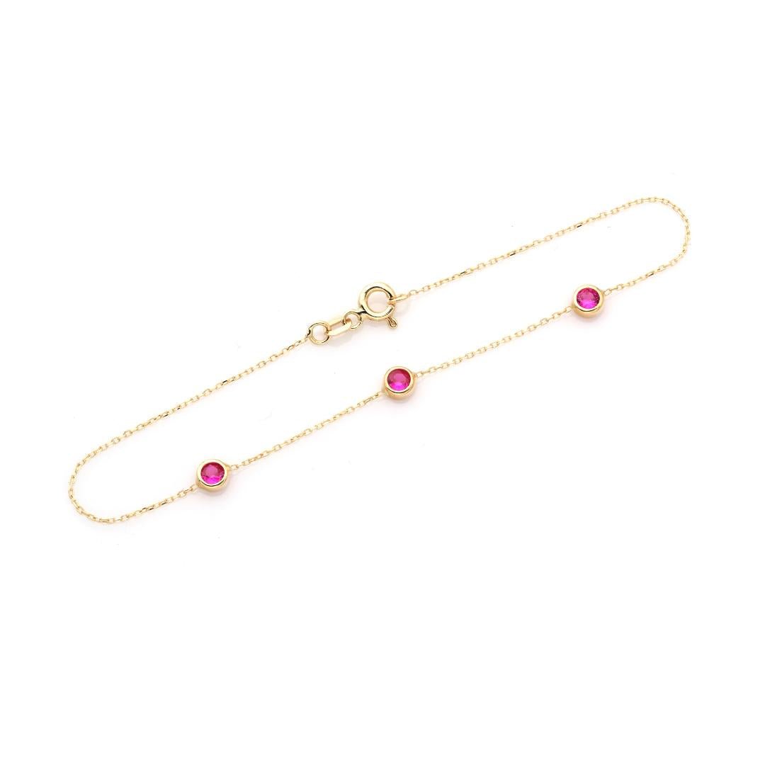 14K yellow gold dainty bracelet with three bezel set lab created rubies, minimalistic design, perfect for everyday wear.