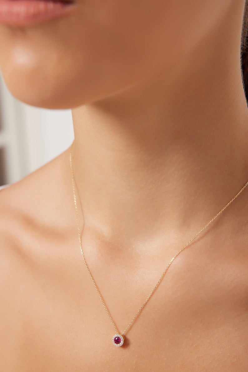 Model wearing a 14K solid yellow gold round solitaire ruby necklace with CZ stones, showcasing elegant simplicity.