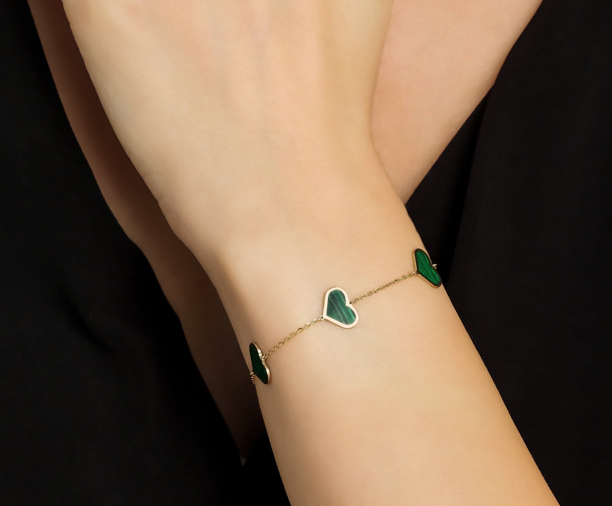 14K solid yellow gold heart bracelet featuring natural malachite, detailed close-up on wrist, elegant gift idea.