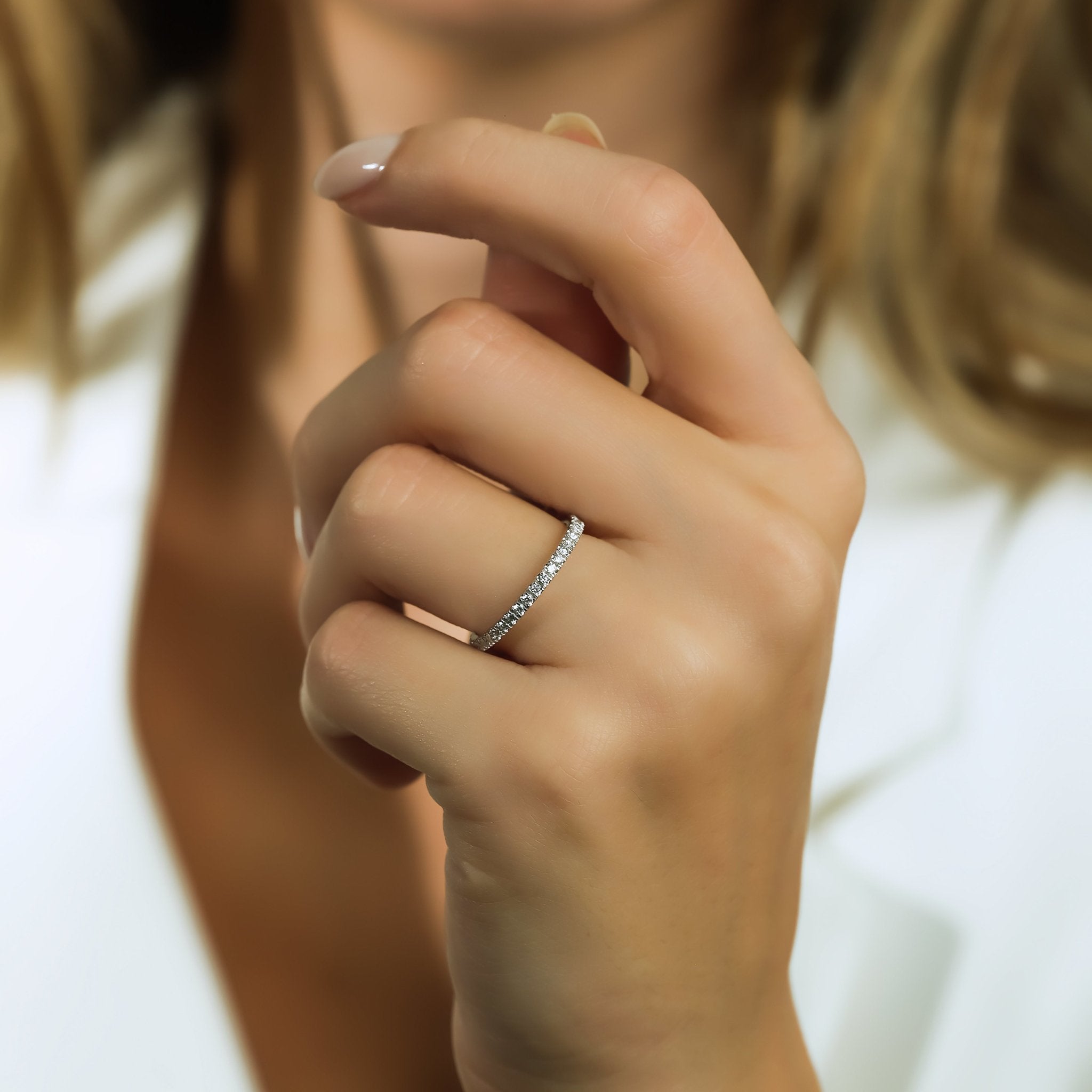 Elegant 14K white gold 0.60 carat diamond wedding band showcased on a woman's hand.
