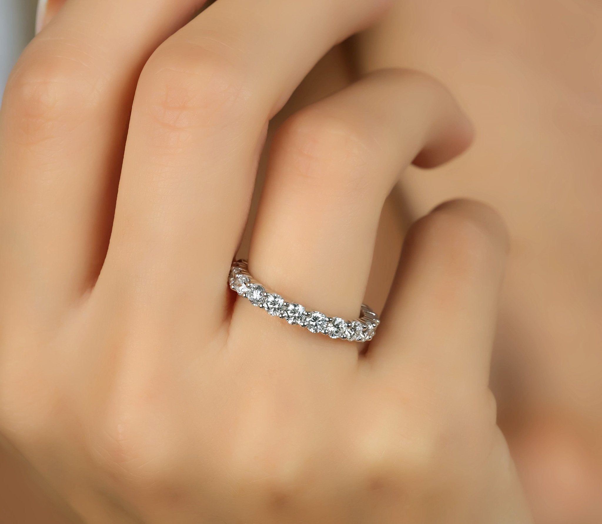 14K white gold 2.10 carat diamond eternity wedding band showcased on a hand, featuring sparkling round diamonds.