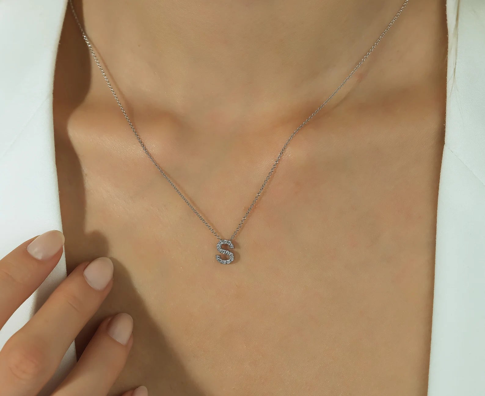 14K solid white gold diamond initial necklace featuring letter S, showcasing elegant sparkle on a model's neck.