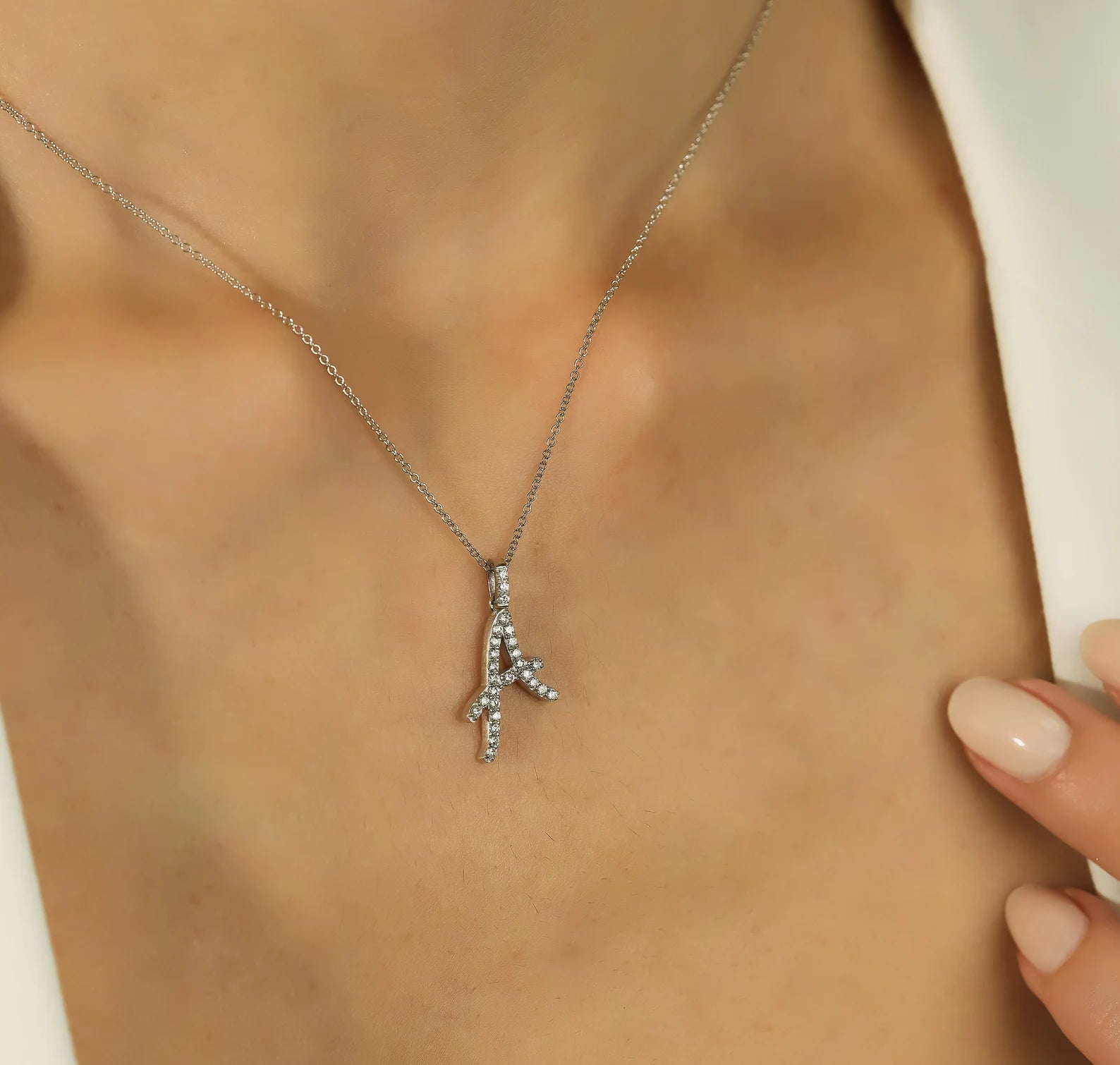 14K solid white gold diamond initial necklace featuring a sparkling script letter A design.