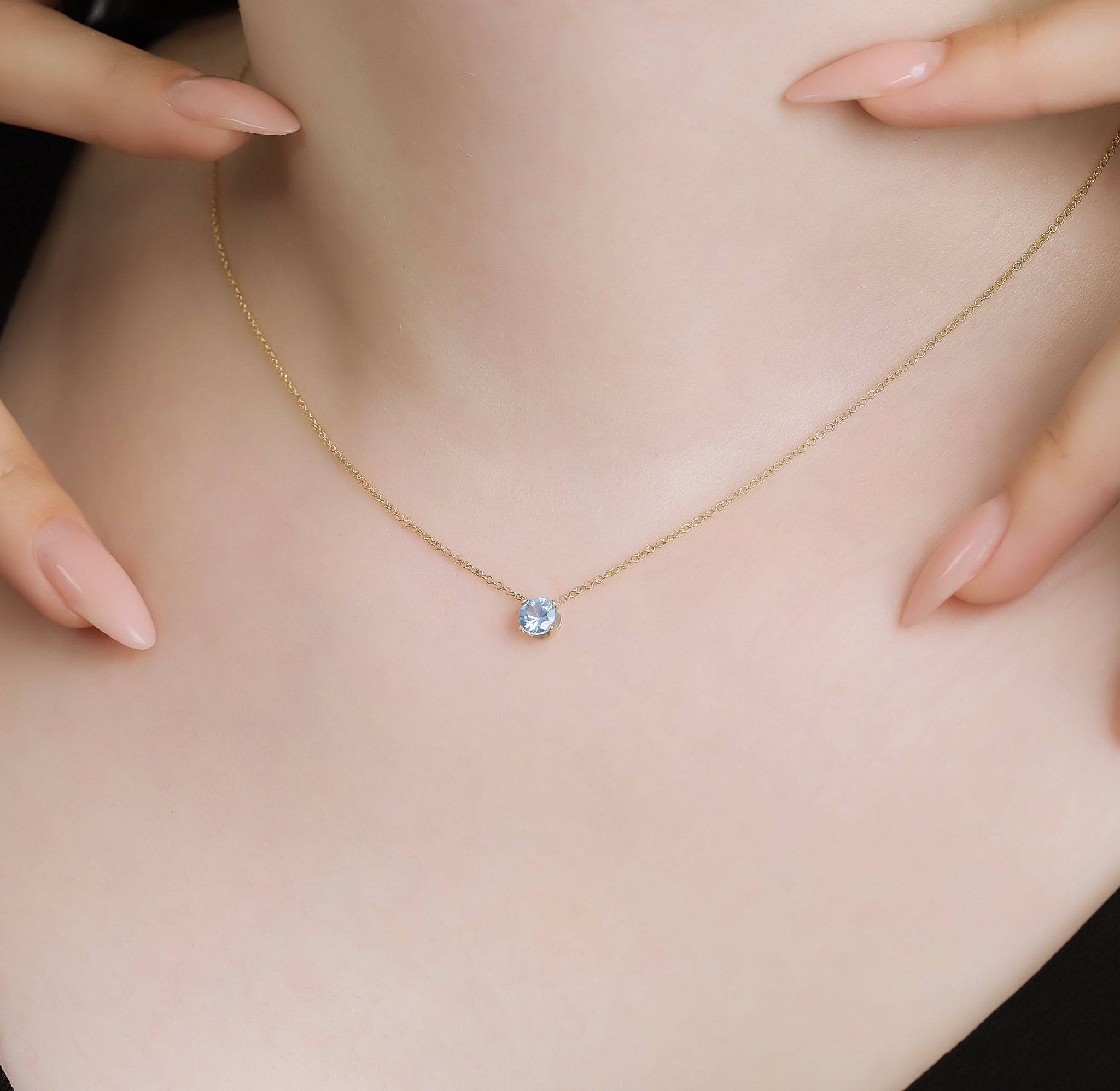Delicate 14K white gold 5mm aquamarine solitaire necklace worn on the neck, showcasing its simple elegance.
