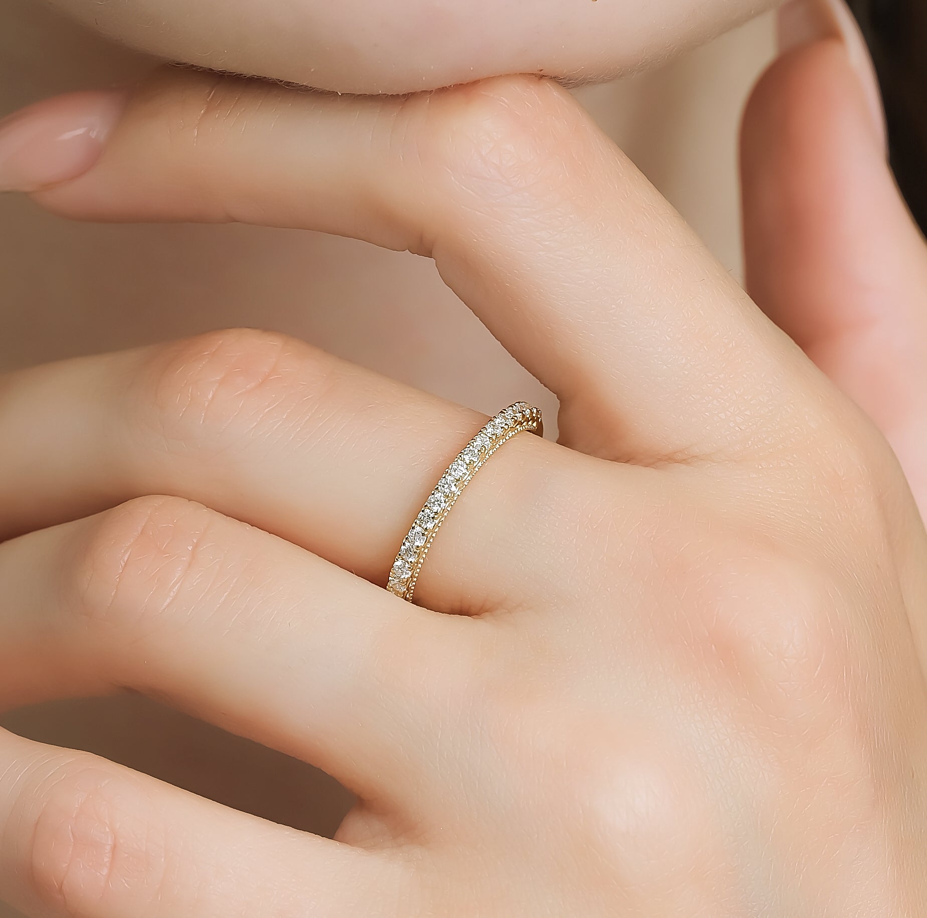 14K gold half eternity diamond wedding ring displayed on a finger with sparkling round diamonds, perfect for engagements or weddings.