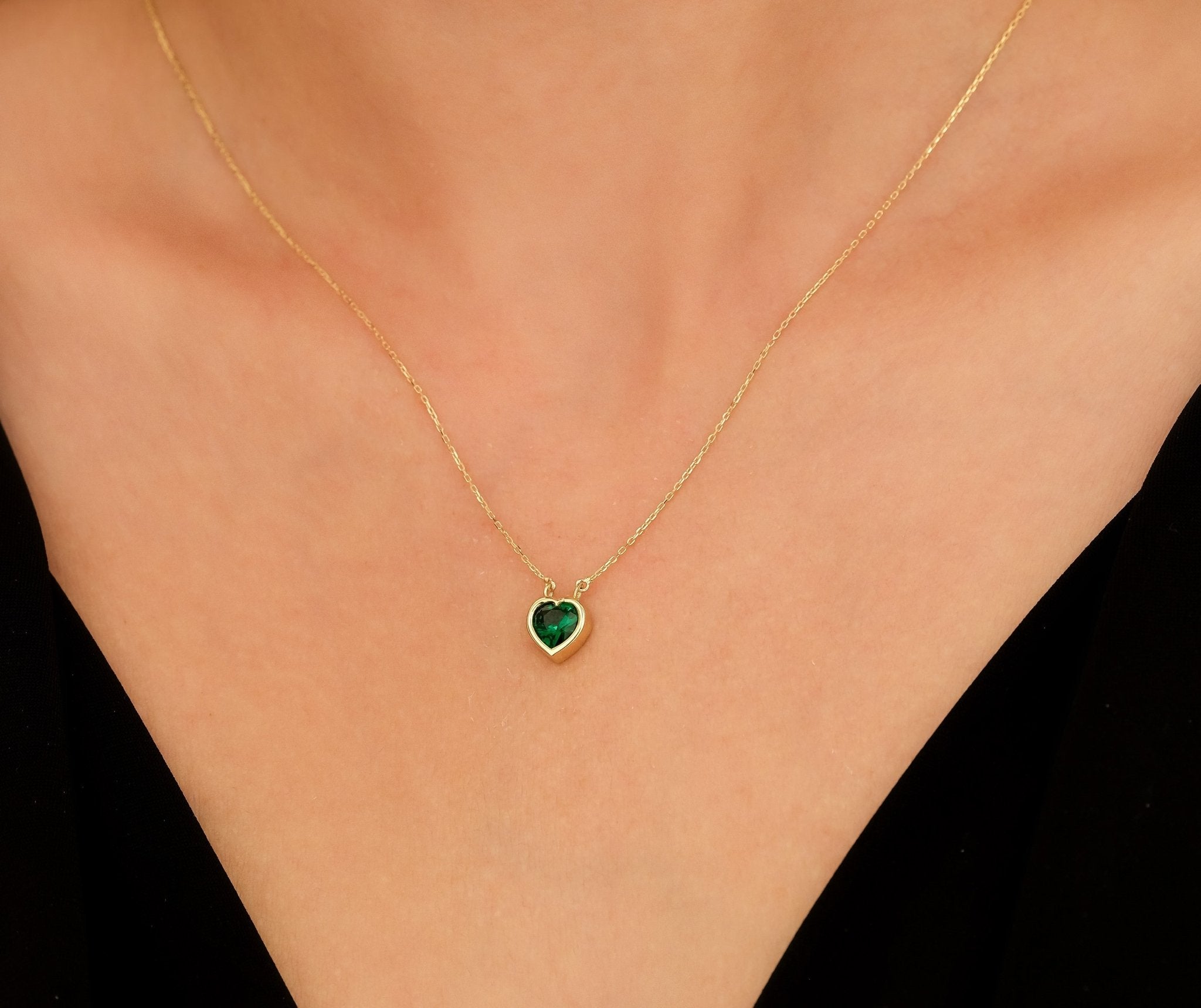 14K yellow gold heart-shaped emerald necklace worn on a model's neck, perfect for classy everyday style.