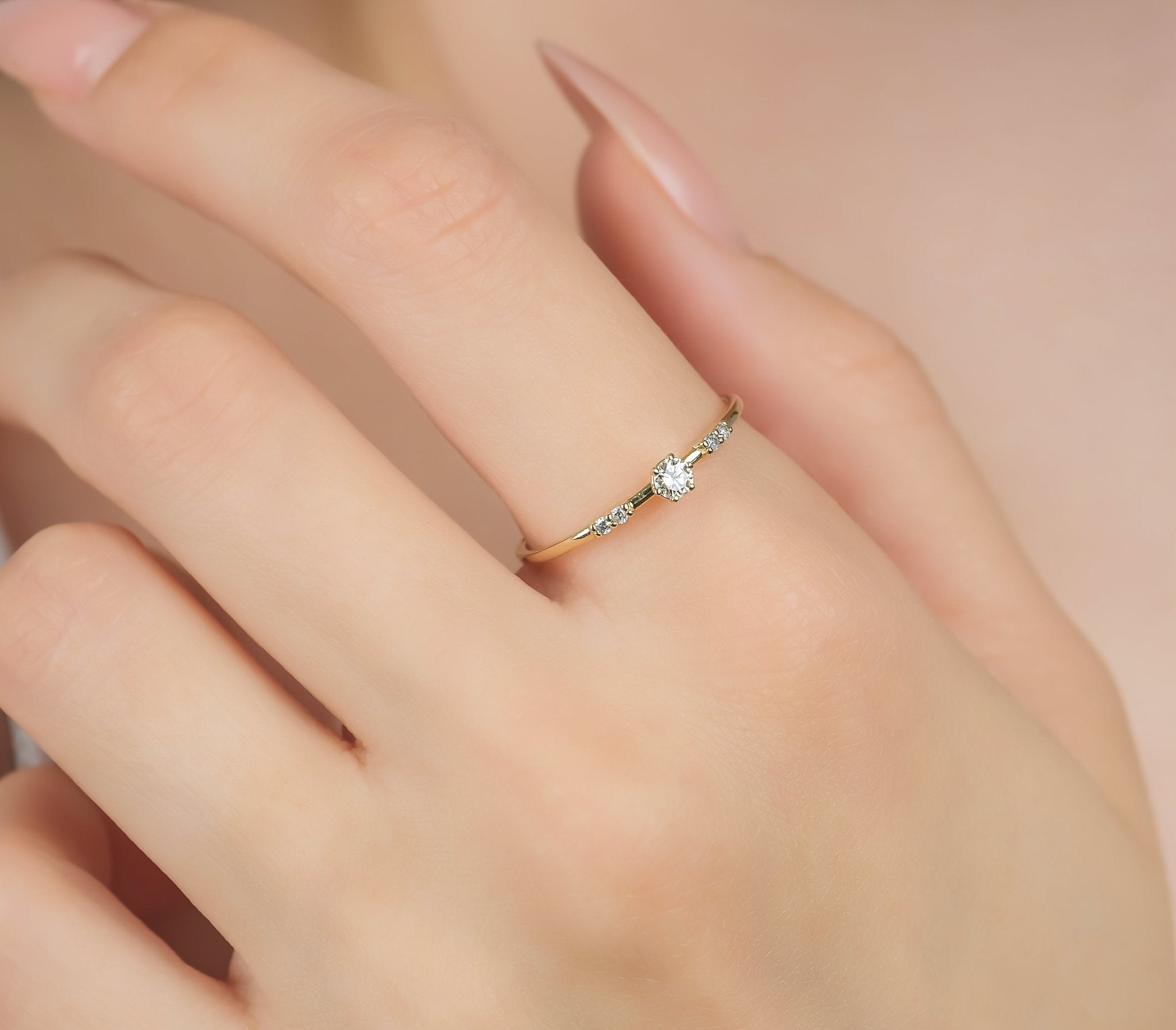 14K yellow gold minimalist women's diamond engagement ring featuring a round center diamond and 5 accent diamonds.