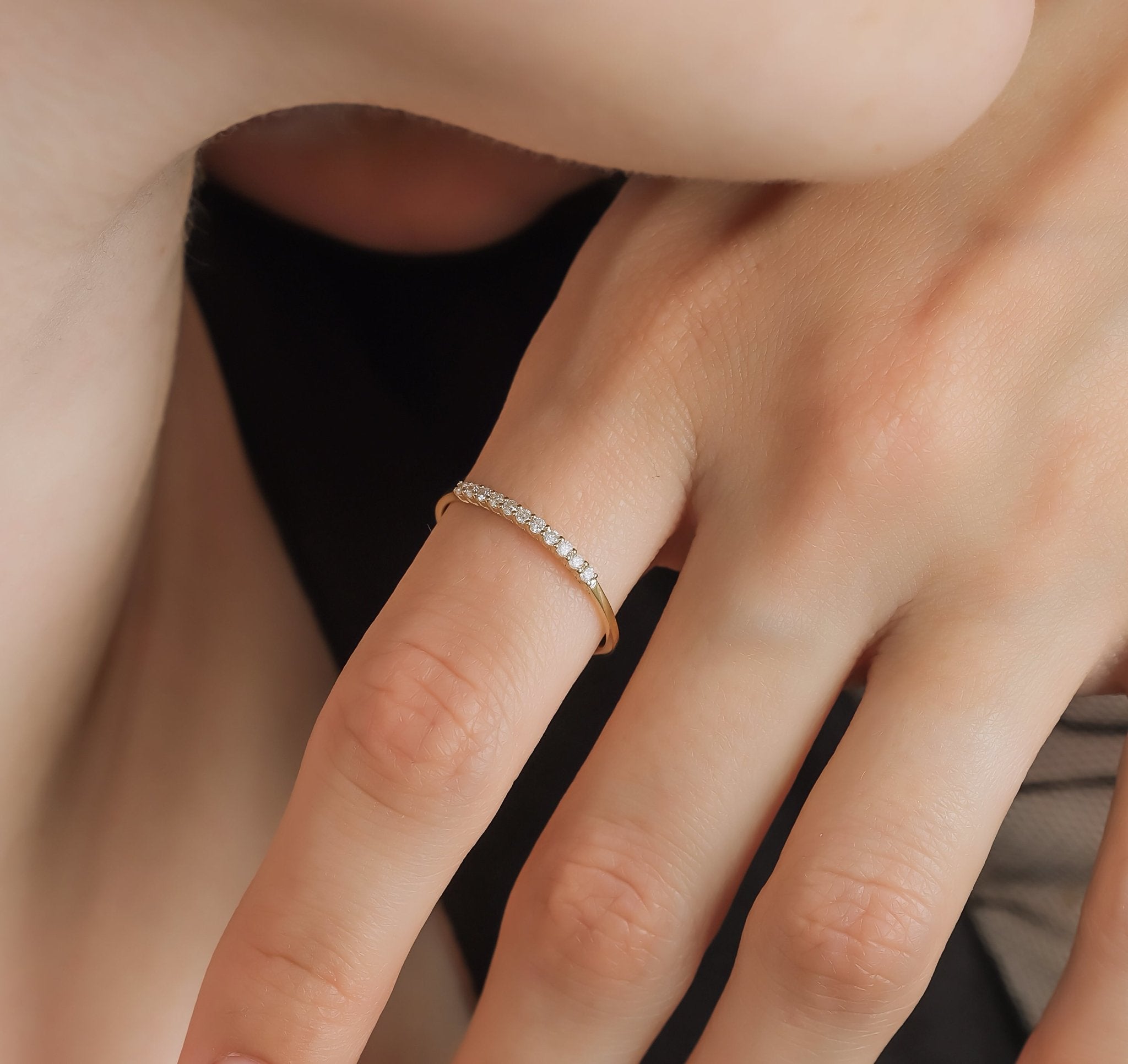 14K gold diamond wedding band on a woman's finger, featuring 11 round diamonds with a shiny finish.