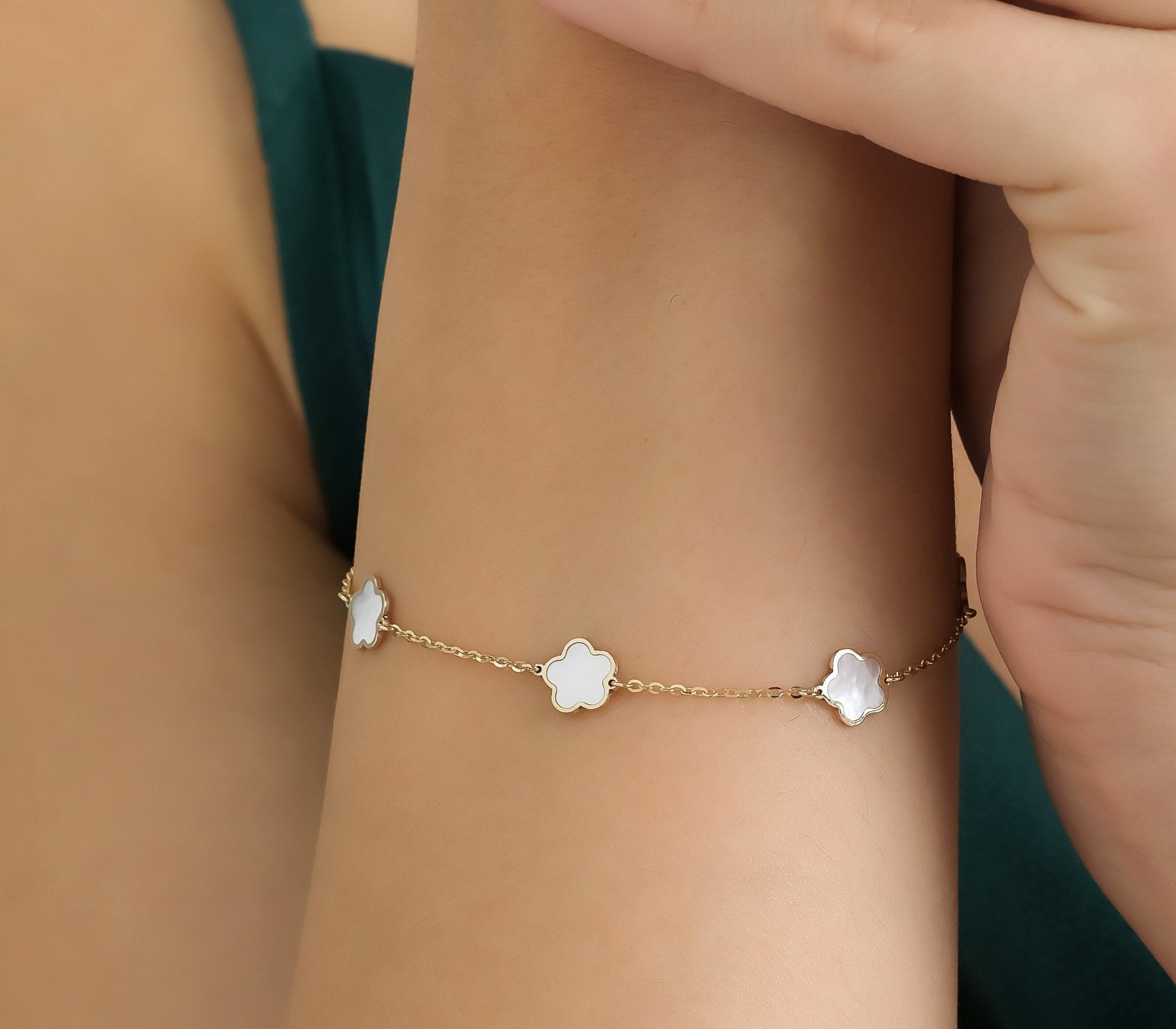 14K yellow gold mother of pearl daisy flower bracelet worn on wrist, showcasing delicate design and elegance.