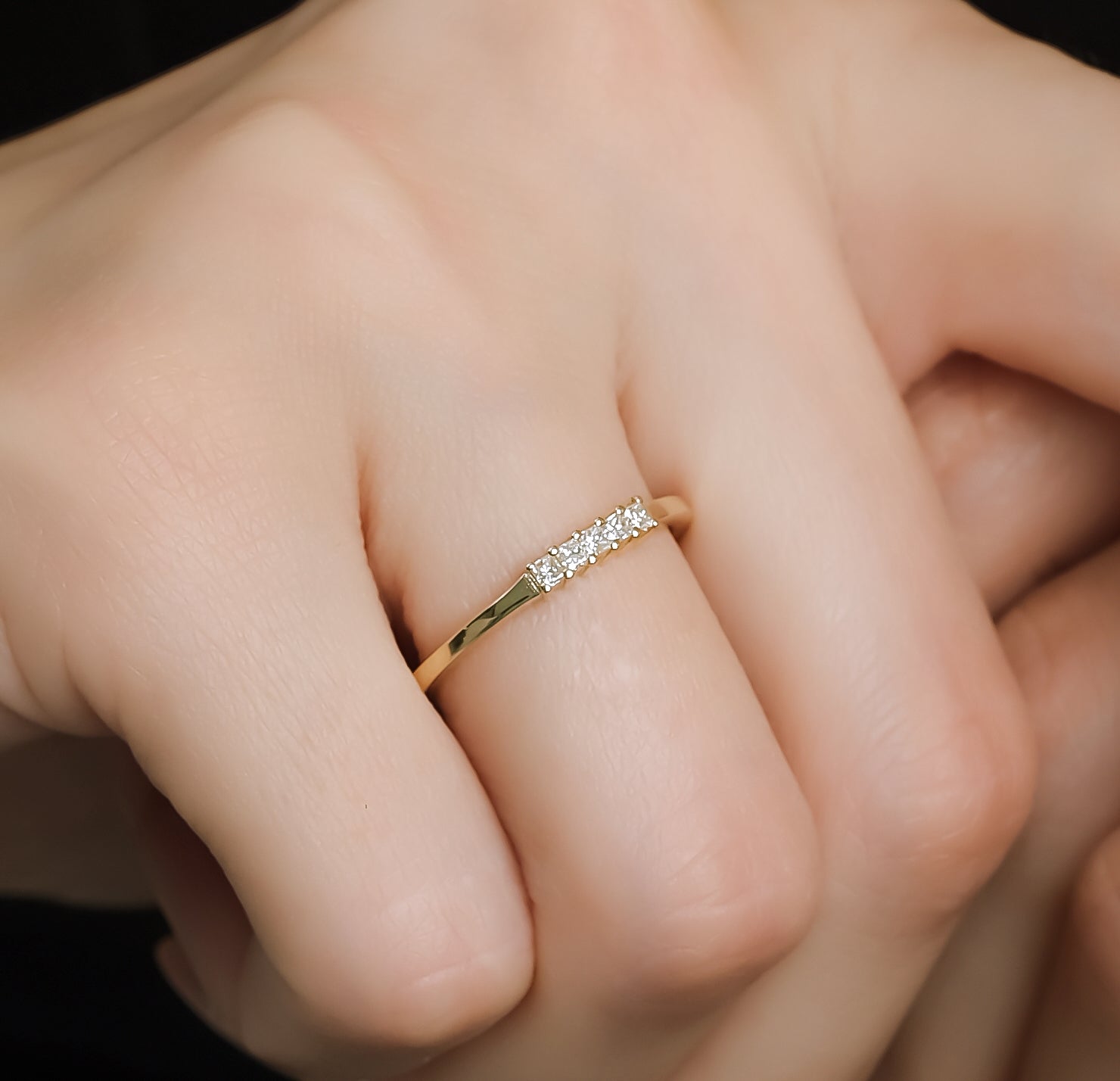 14K gold princess cut diamond wedding ring with five sparkling diamonds, displayed on a hand for elegant wedding jewelry.