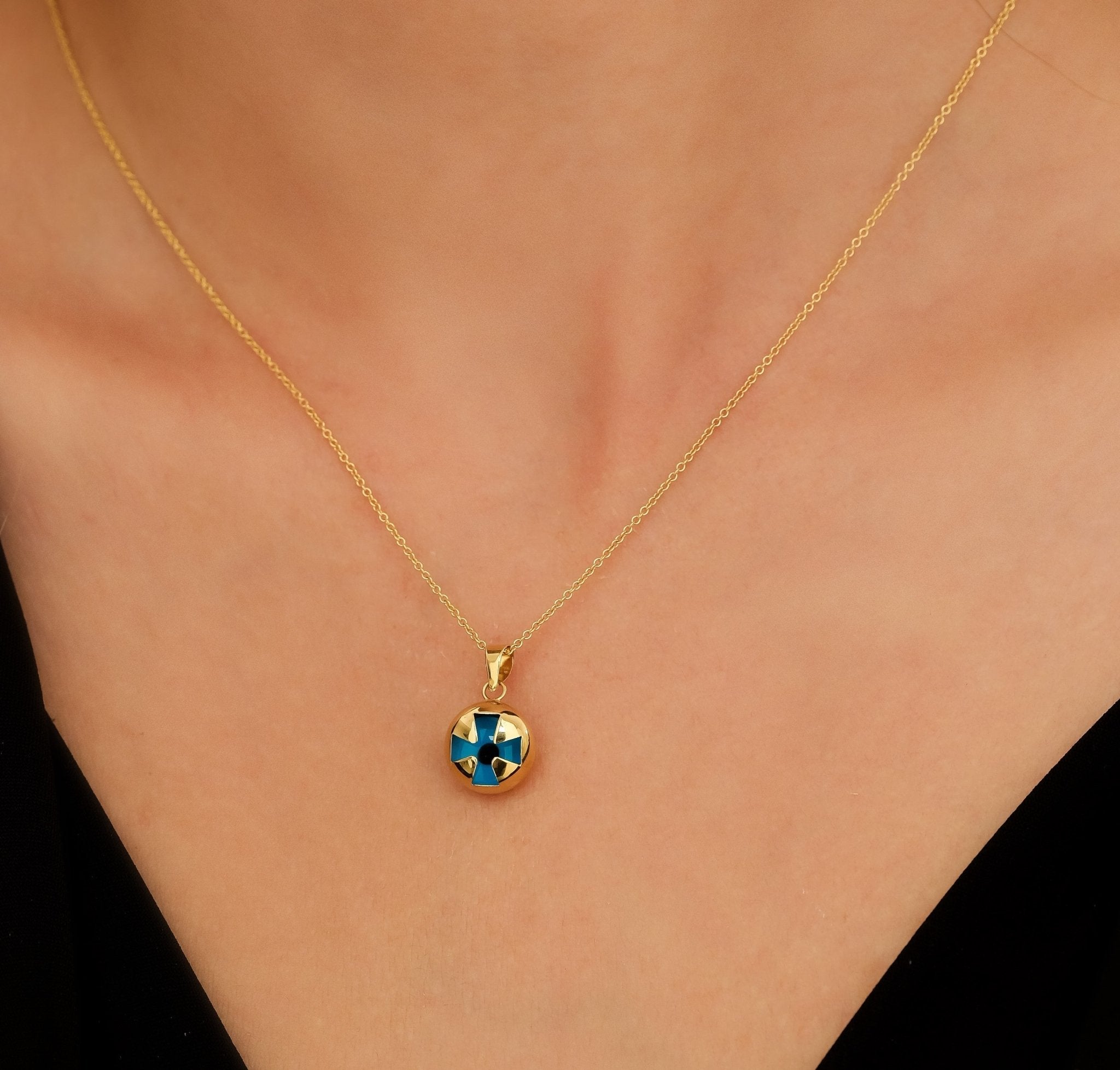 14K yellow gold evil eye cross necklace on a model, featuring a unique puffed design, ideal for everyday wear.