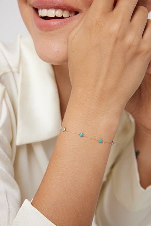 14K gold beaded station turquoise bracelet displayed on wrist, showcasing its delicate design and simplicity.