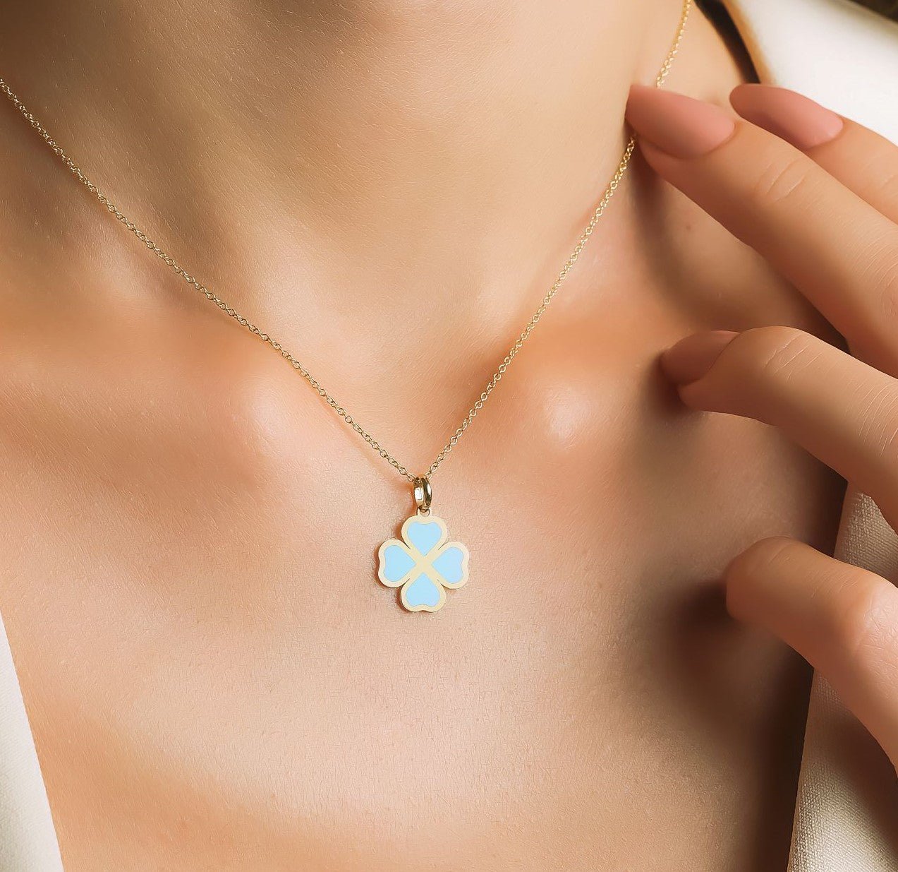 14K yellow gold turquoise four leaf clover necklace on a model, showcasing its dainty design and elegant charm.