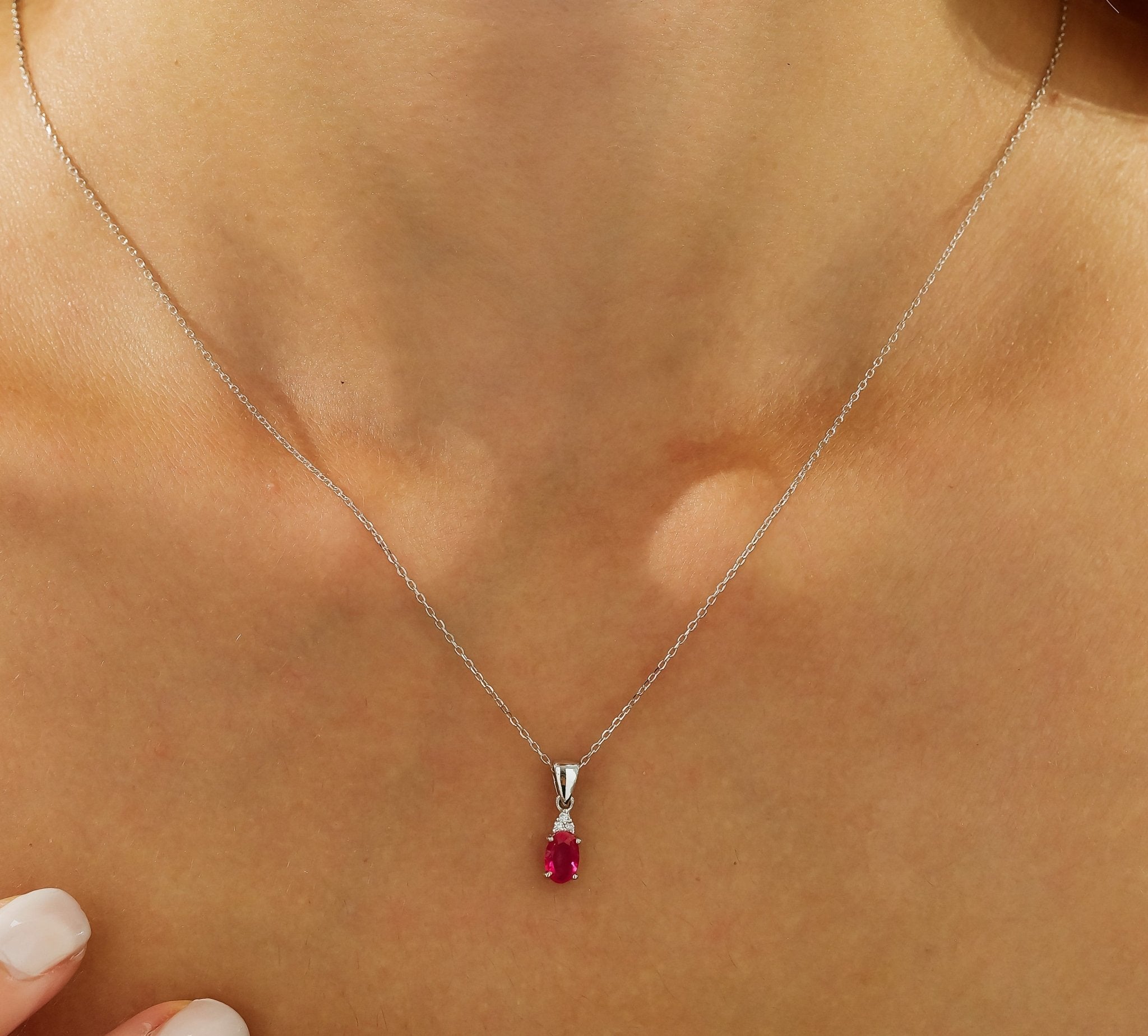 14K white gold necklace featuring a lab-created oval ruby pendant and natural diamonds, perfect for everyday wear.
