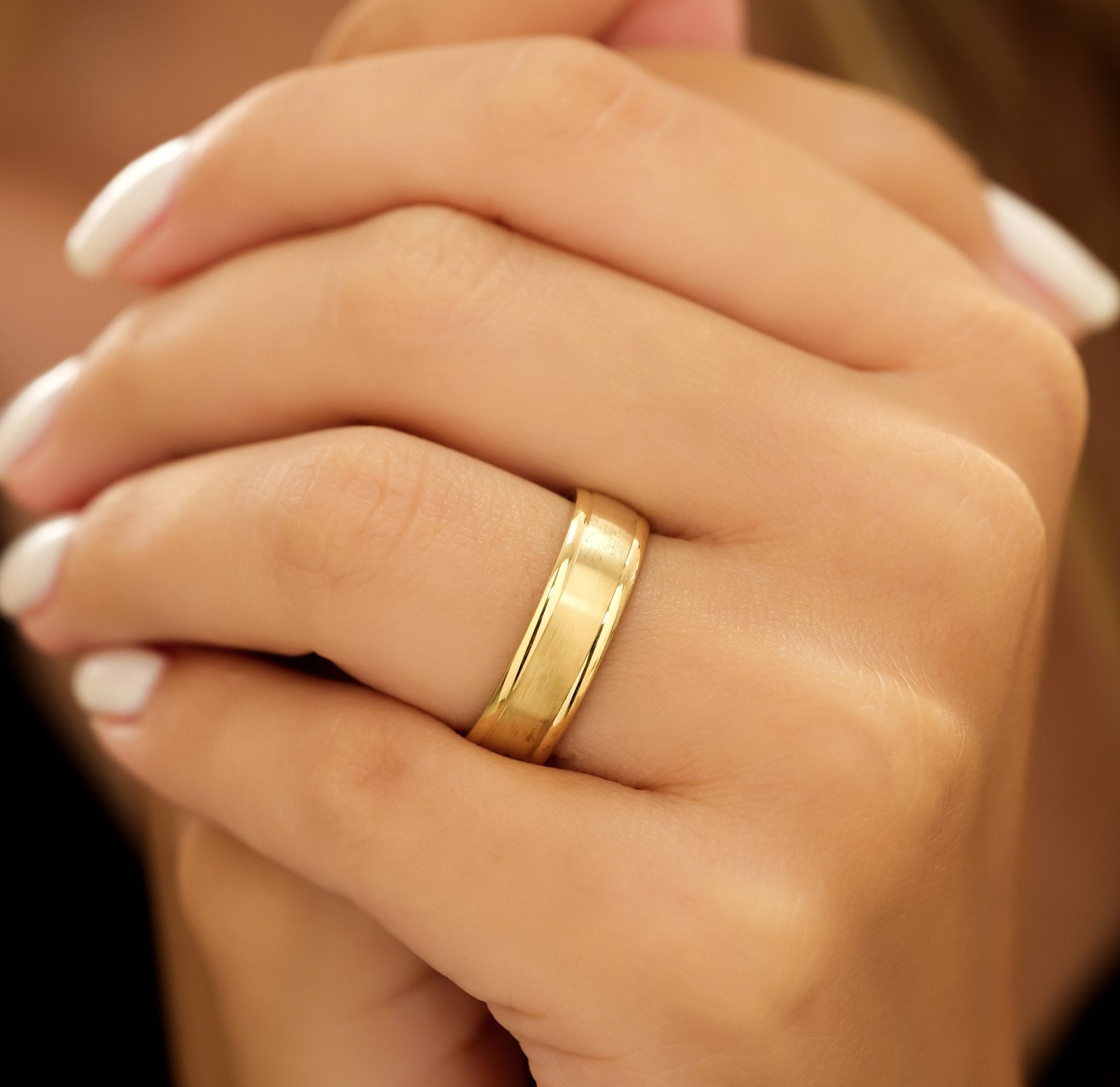 6mm yellow gold men's wedding band on a hand, featuring shiny edges and a satin finish.