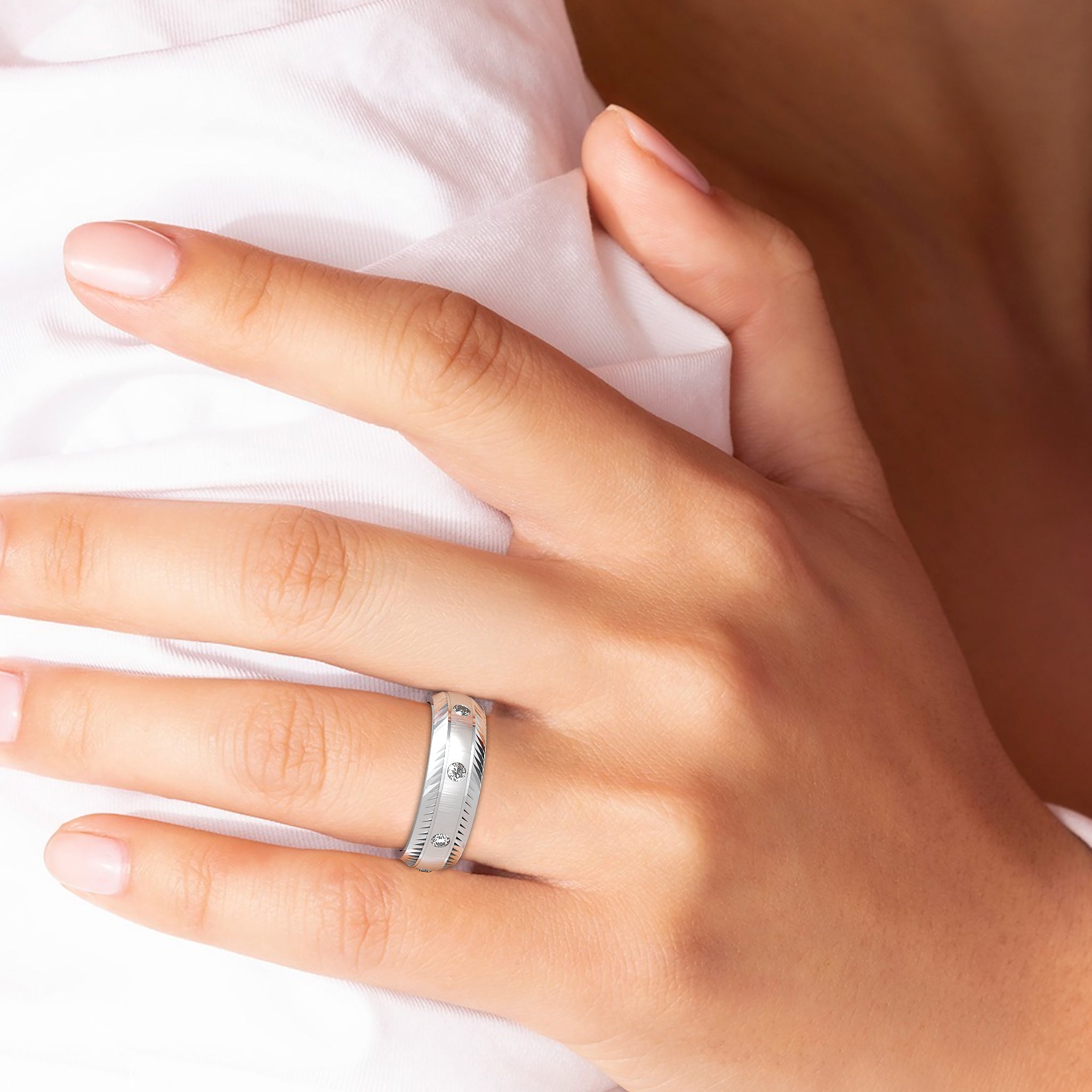 Close-up of a hand wearing a silver wedding band, showcasing a comfort fit design.