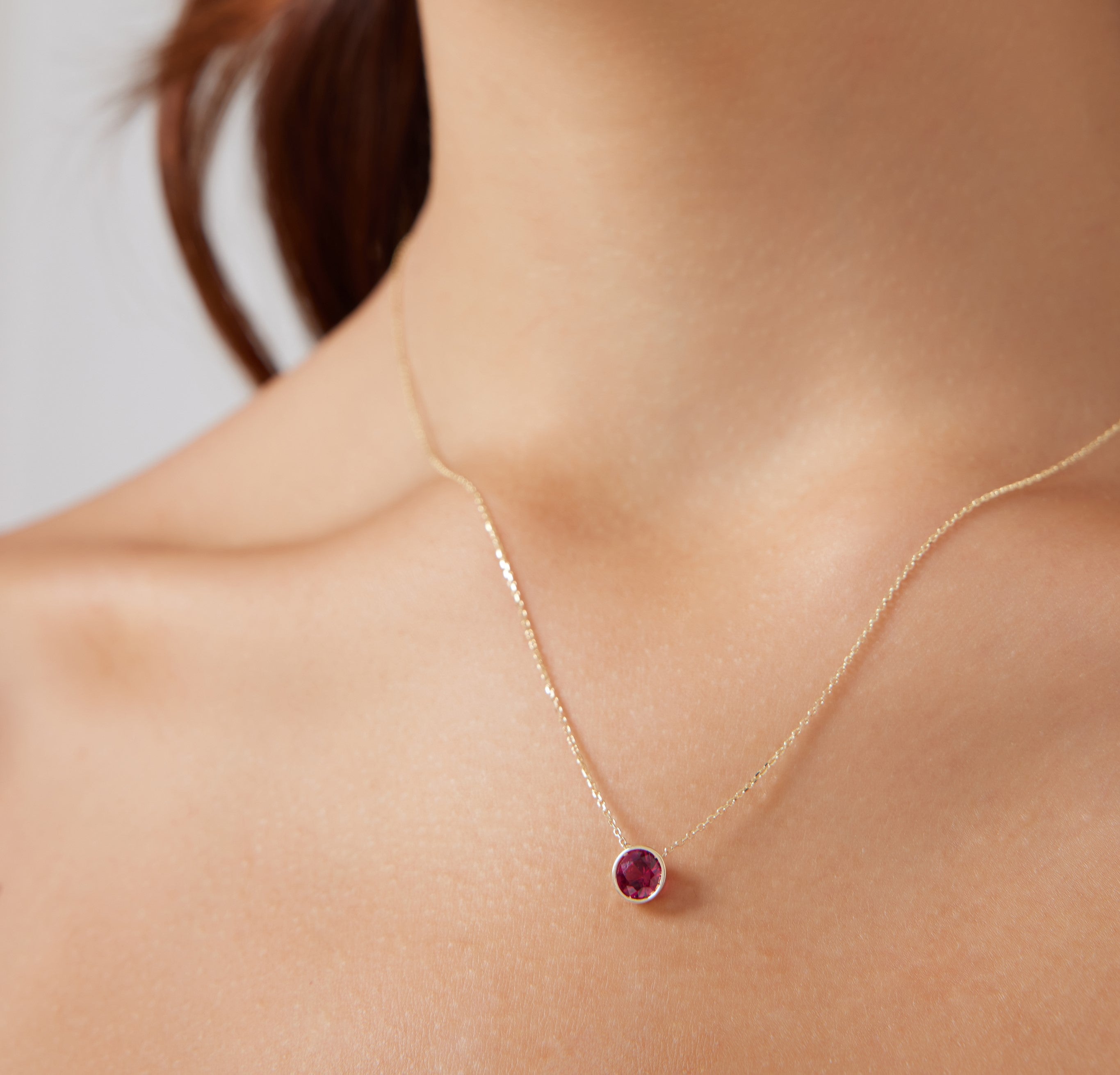 14K yellow gold necklace featuring a 6mm bezel-set lab-created ruby solitaire pendant, ideal for everyday wear.