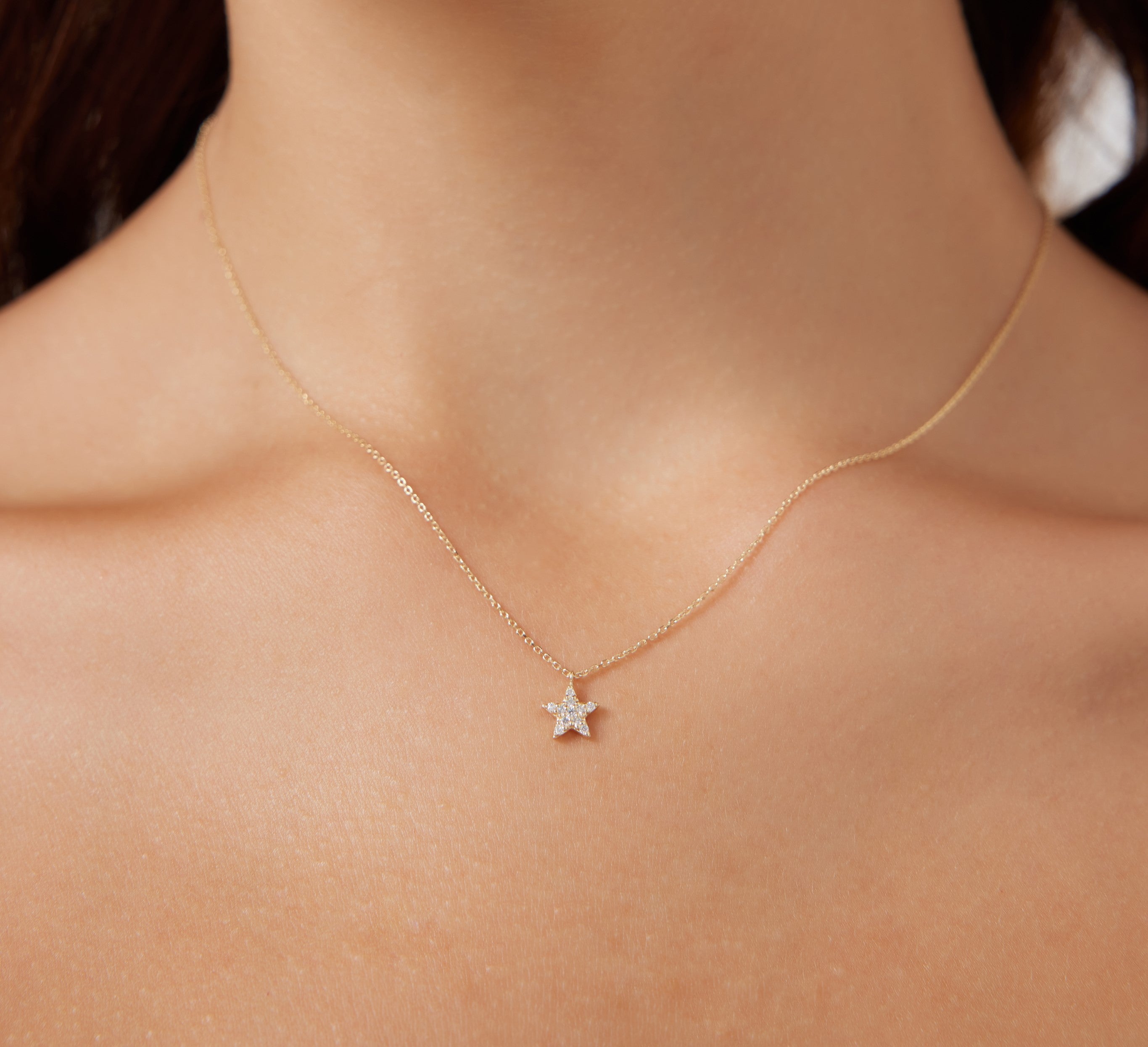 14K solid yellow gold diamond star necklace worn on a model, featuring delicate minimalist design and white sparkling diamonds.